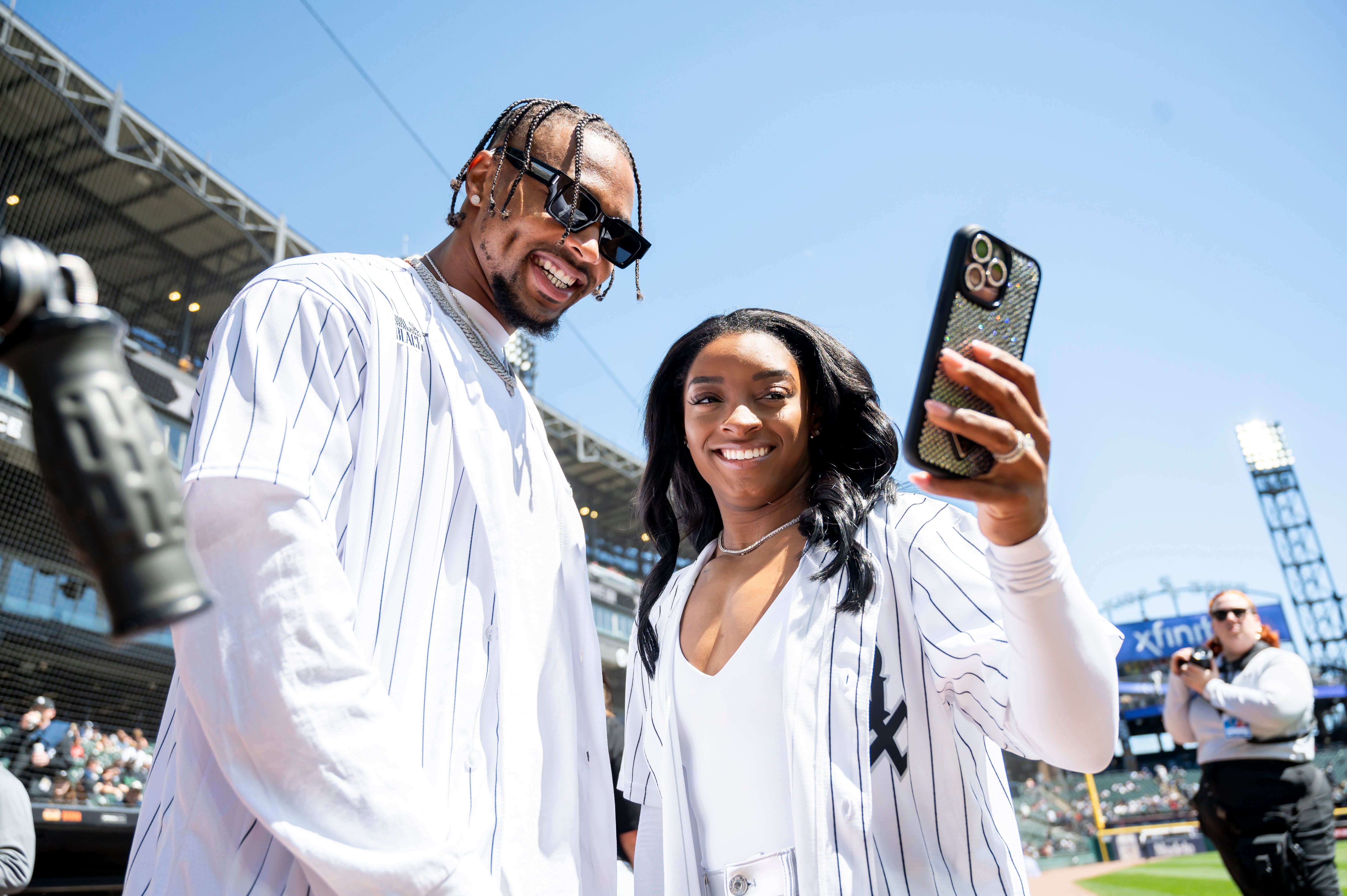 Apr 13, 2024; Chicago, Illinois, USA; Chicago Bears safety Jonathan Owens and American gymnast Simone Biles take a selfie prior to a game between the Chicago White Sox and the Cincinnati Reds at Guaranteed Rate Field.