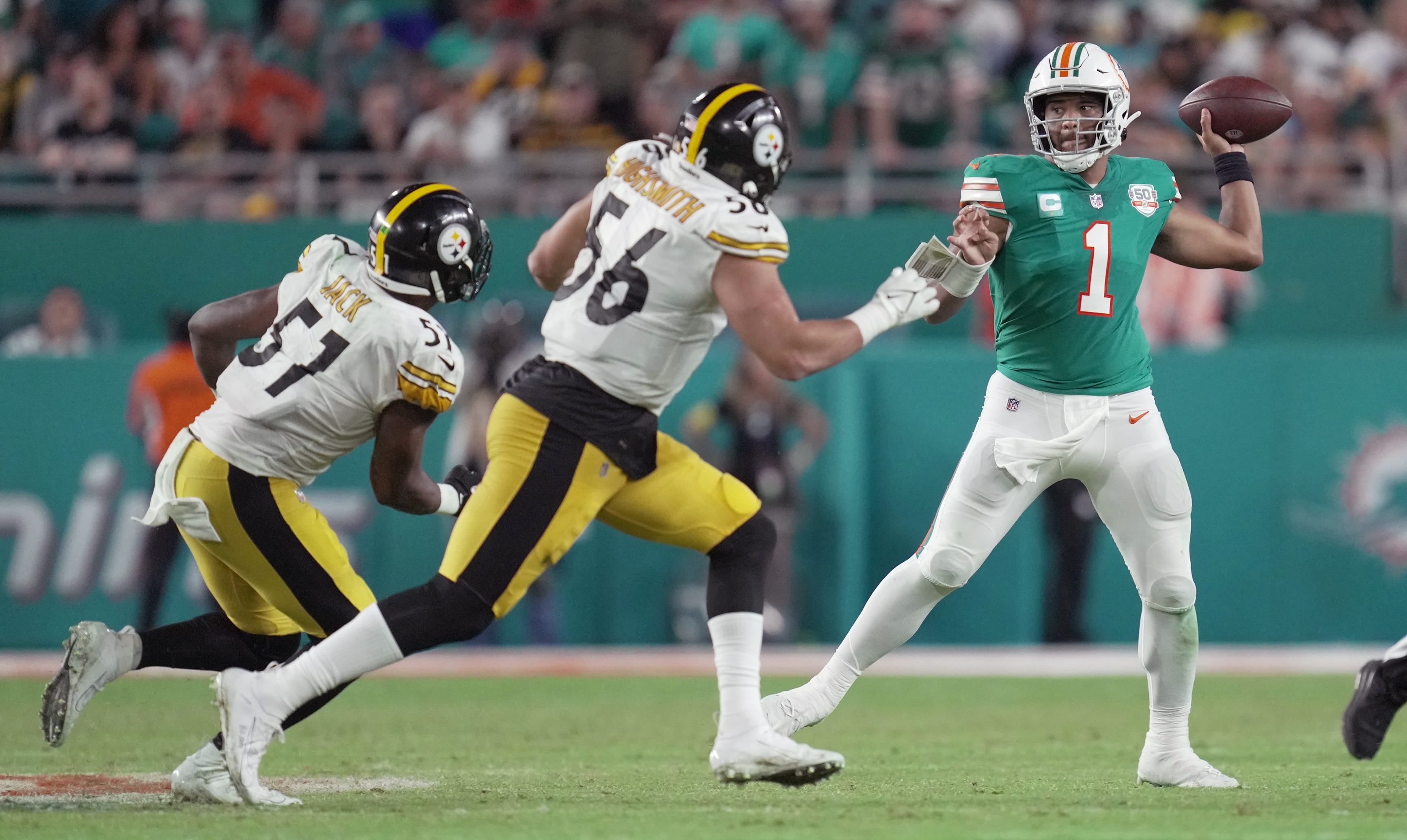 Miami Dolphins quarterback Tua Tagovailoa (1) drops back to pass in the fourth quarter as Pittsburgh Steelers linebacker Alex Highsmith (56) and defensive tackle Montravius Adams (57) close in on the play at Hard Rock Stadium in Miami Gardens, Oct. 23, 2022. Week 7 Dolphins Vs Pittsburgh Steelers Jr3498