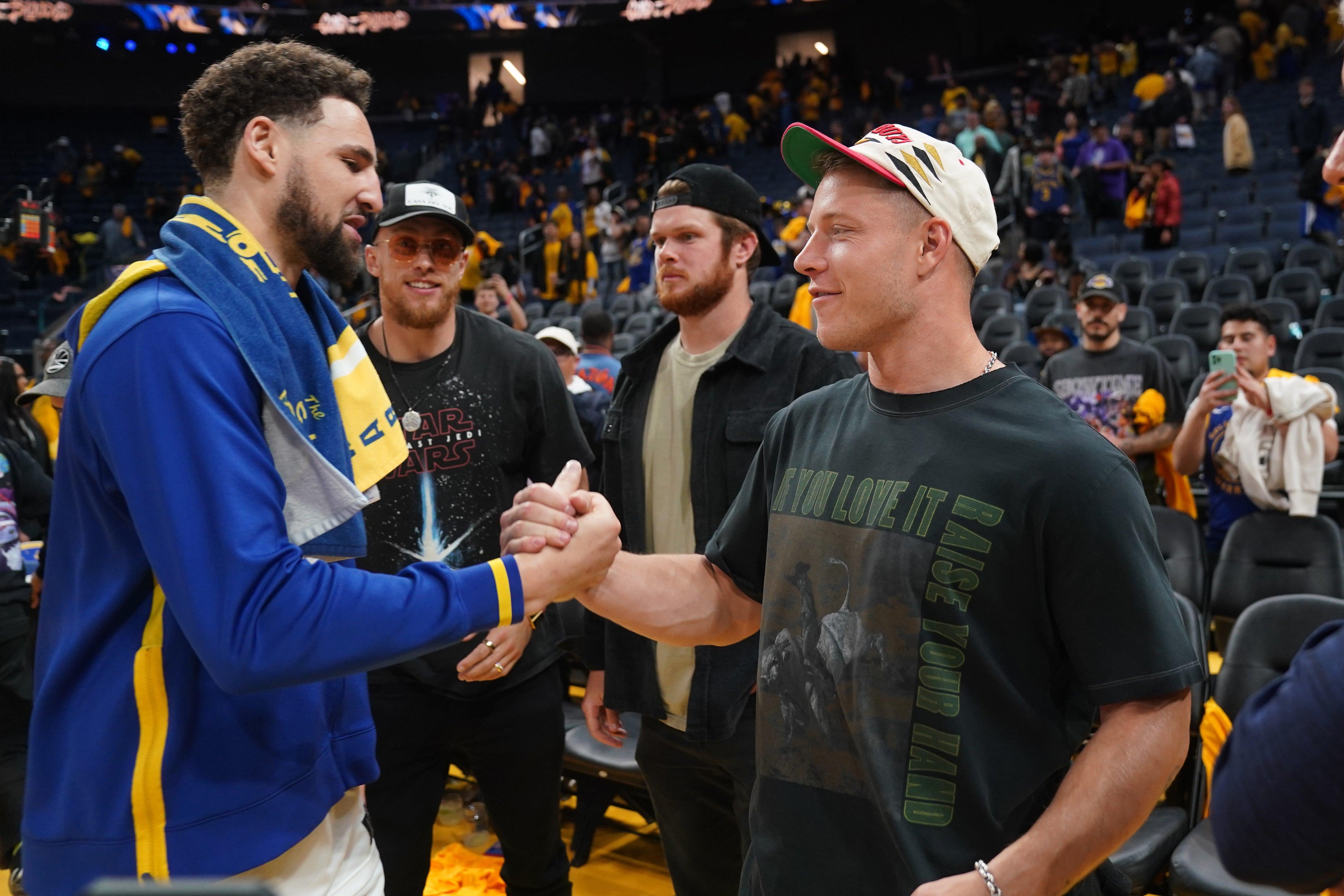 May 4, 2023; San Francisco, California, USA; Golden State Warriors guard Klay Thompson (11) meets with San Francisco 49ers running back Christian McCaffrey after game two of the 2023 NBA playoffs against the Los Angeles Lakers at the Chase Center.