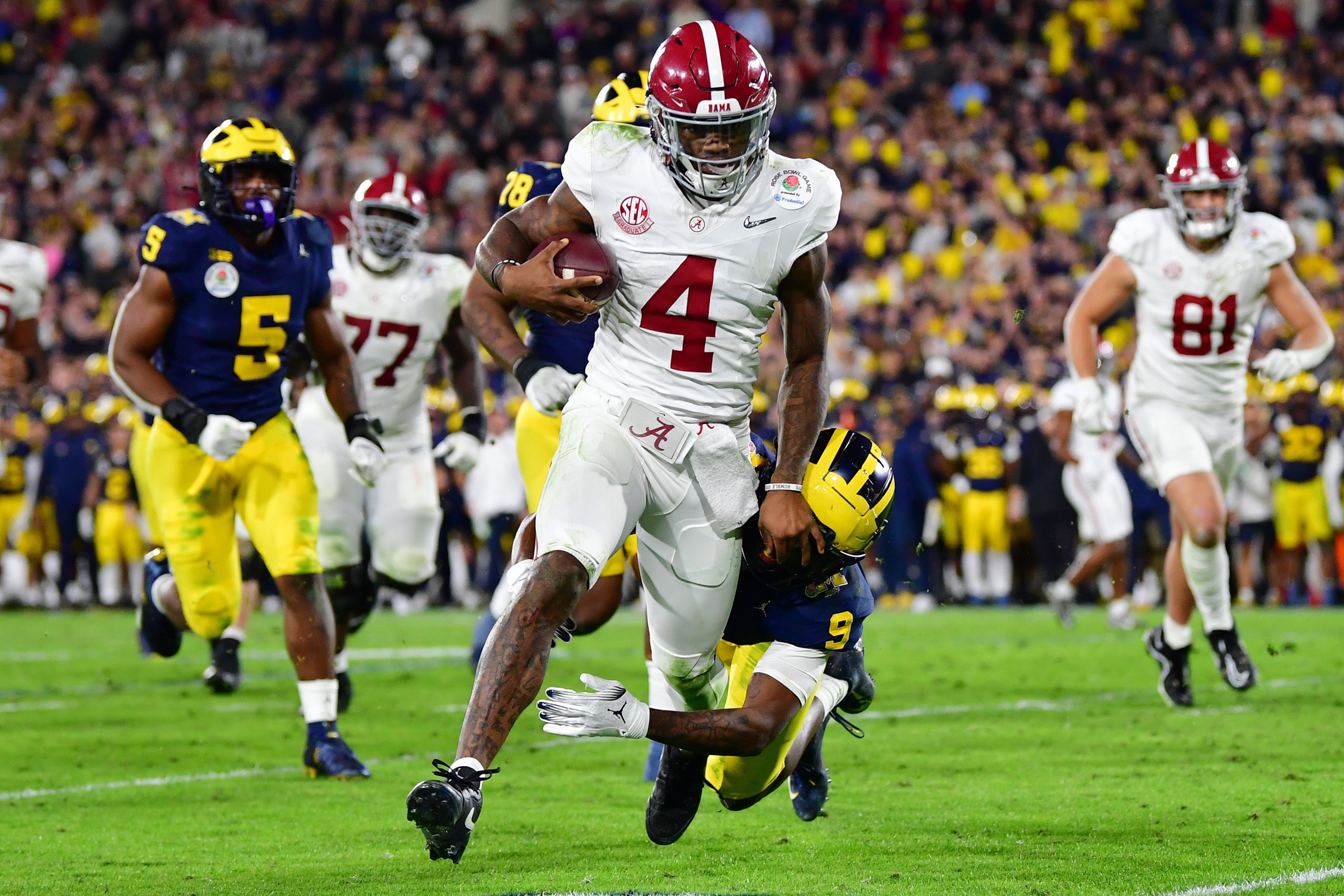 Jan 1, 2024; Pasadena, CA, USA; Alabama Crimson Tide quarterback Jalen Milroe (4) runs against Michigan Wolverines defensive back Rod Moore (9) in overtime in the 2024 Rose Bowl college football playoff semifinal game at Rose Bowl. Mandatory Credit: Gary A. Vasquez-USA TODAY Sports