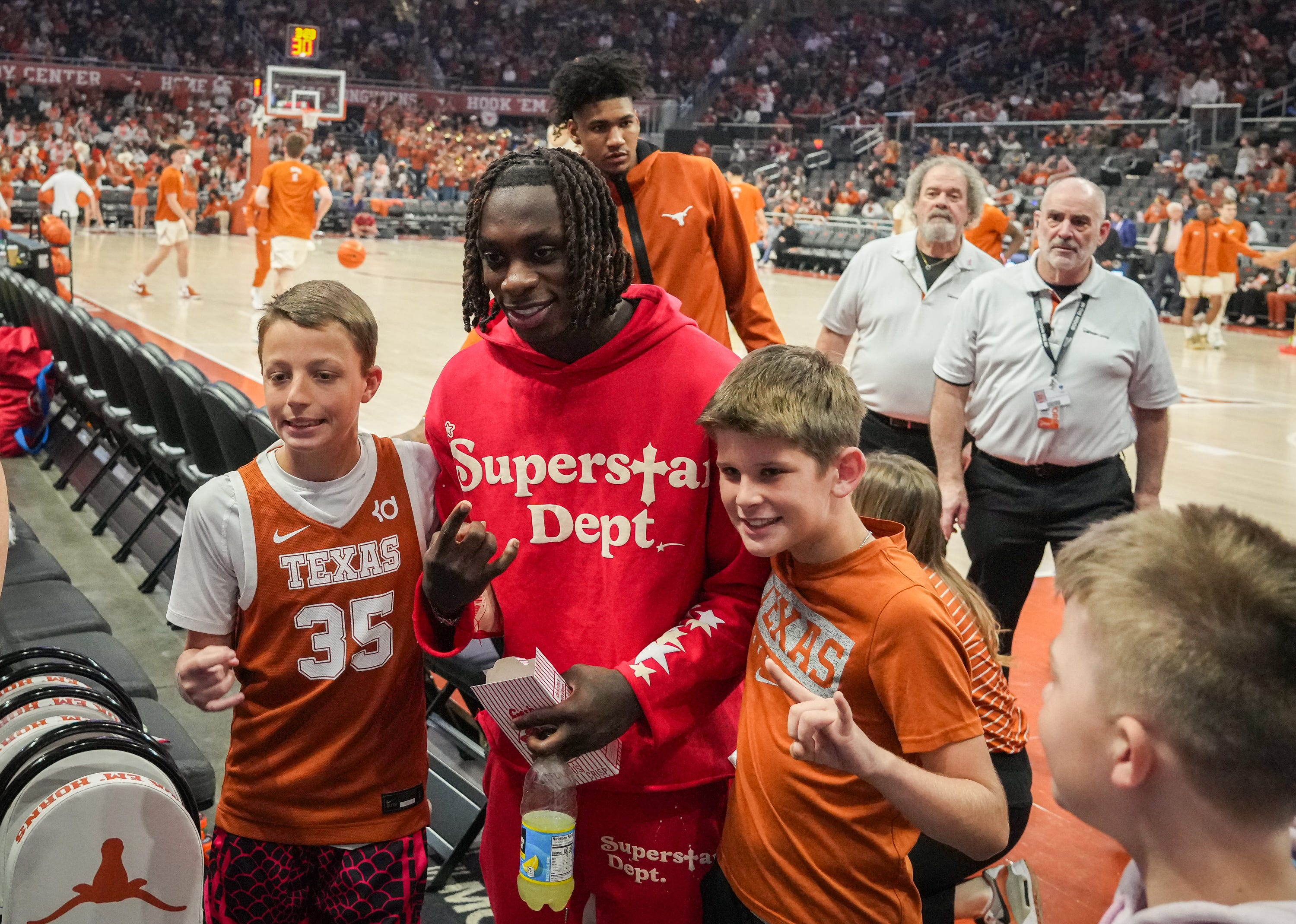 Xavier Worthy takes photos with fans during halftime of the Texas Longhorns' basketball game against the Oklahoma Sooners at the Moody Center in Austin, Saturday, March 9, 2024. Texas won the game 94-80.
