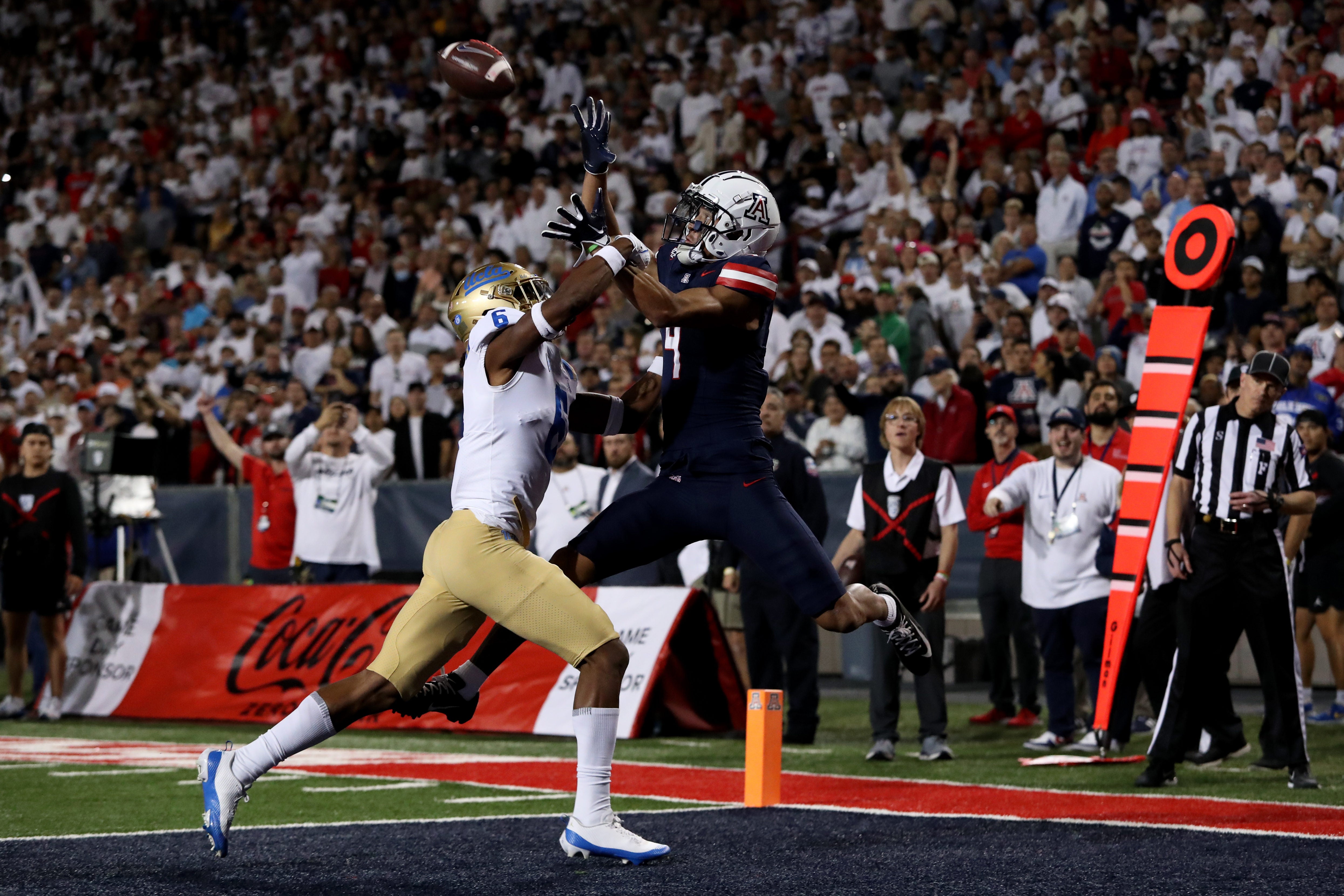 Nov 4, 2023; Tucson, Arizona, USA; Arizona Wildcats wide receiver Tetairoa McMillan #4 makes a catch for a touchdown agaisnt UCLA Bruins defensive back John Humphrey #6 during the second half at Arizona Stadium.