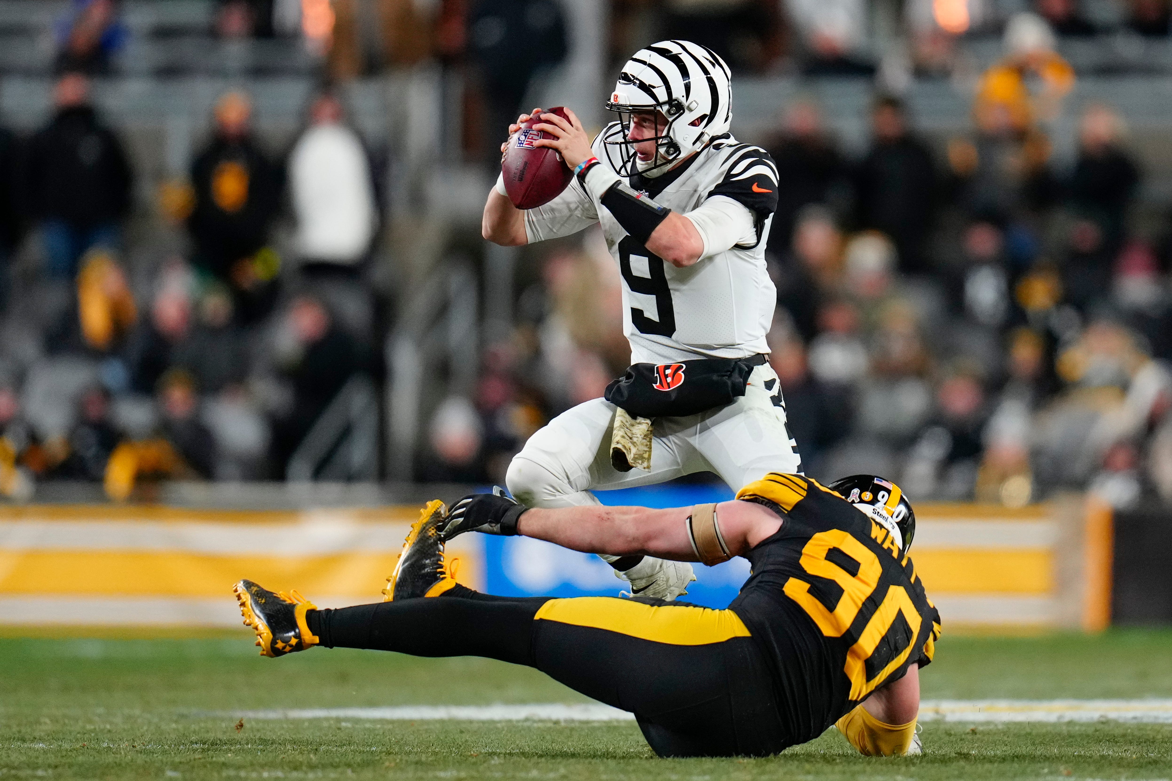 Cincinnati Bengals quarterback Joe Burrow (9) evades a sack from Pittsburgh Steelers linebacker T.J. Watt (90) in the third quarter of of the NFL Week 11 game between the Pittsburgh Steelers and the Cincinnati Bengals at Acrisure Stadium in Pittsburgh on Sunday, Nov. 20, 2022. The Bengals won 37-30. Cincinnati Bengals At Pittsburgh Steelers Week 11