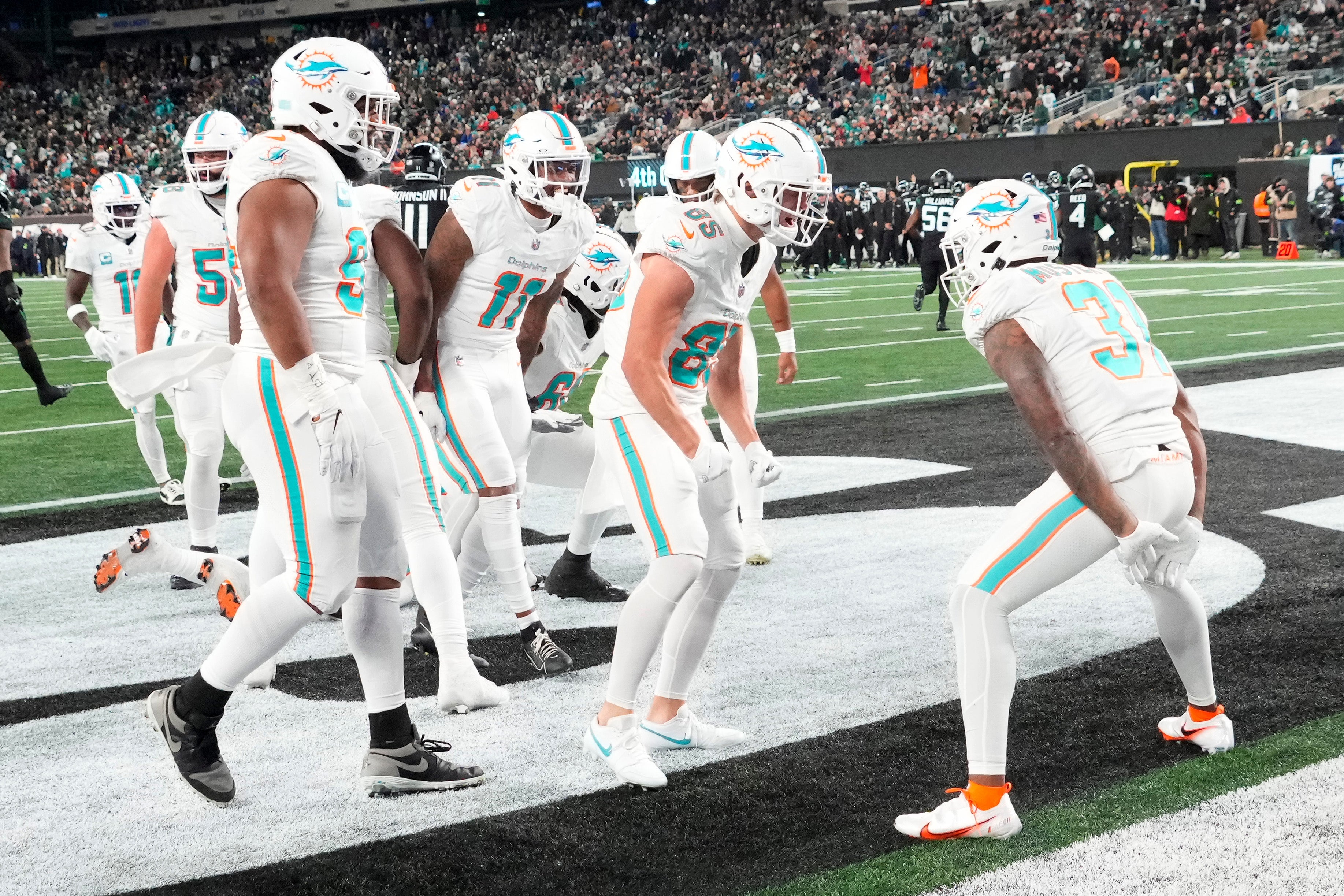 Nov 24, 2023; East Rutherford, New Jersey, USA; Miami Dolphins running back Raheem Mostert (31) joins his teammates in celebrating his second half touchdown against the New York Jets at MetLife Stadium.