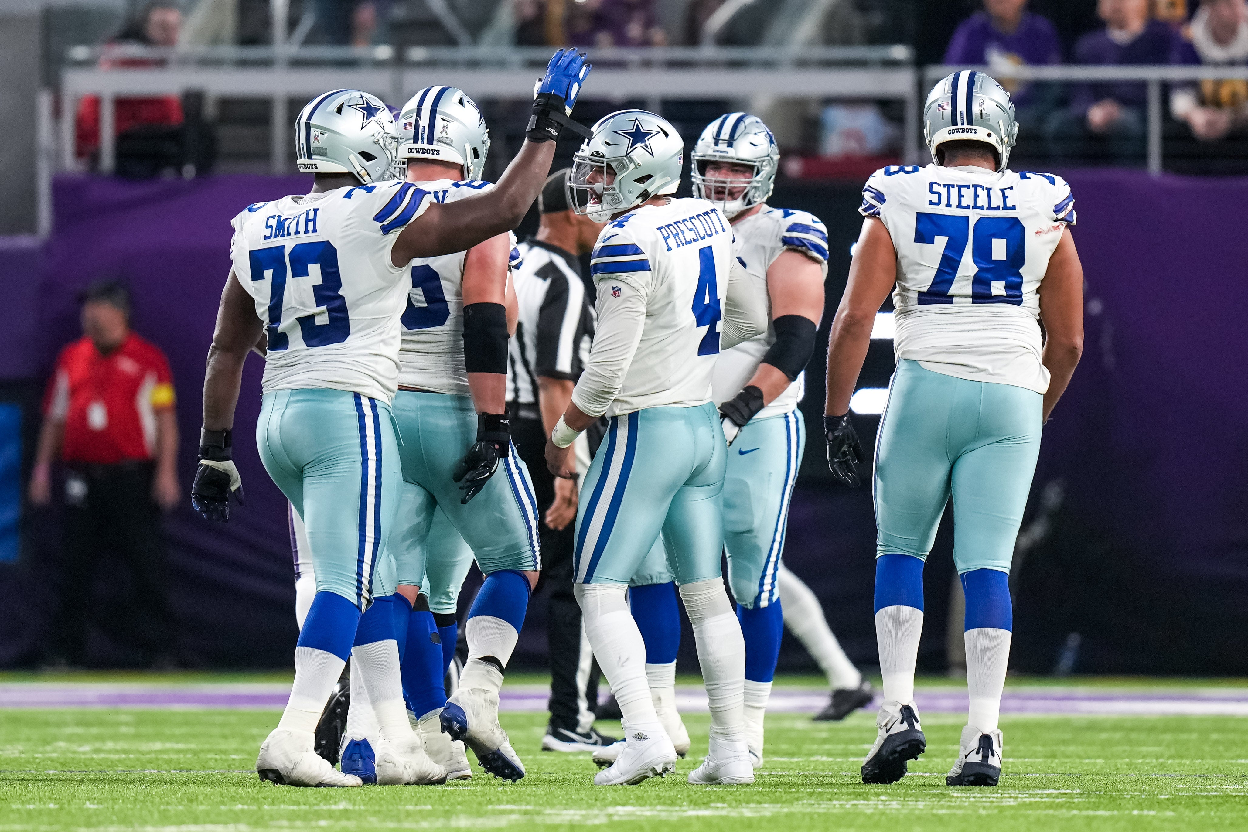 Dallas Cowboys quarterback Dak Prescott (4) celebrates a touchdown with offensive tackle Tyler Smith (73) during the second quarter against the Minnesota Vikings at U.S. Bank Stadium.