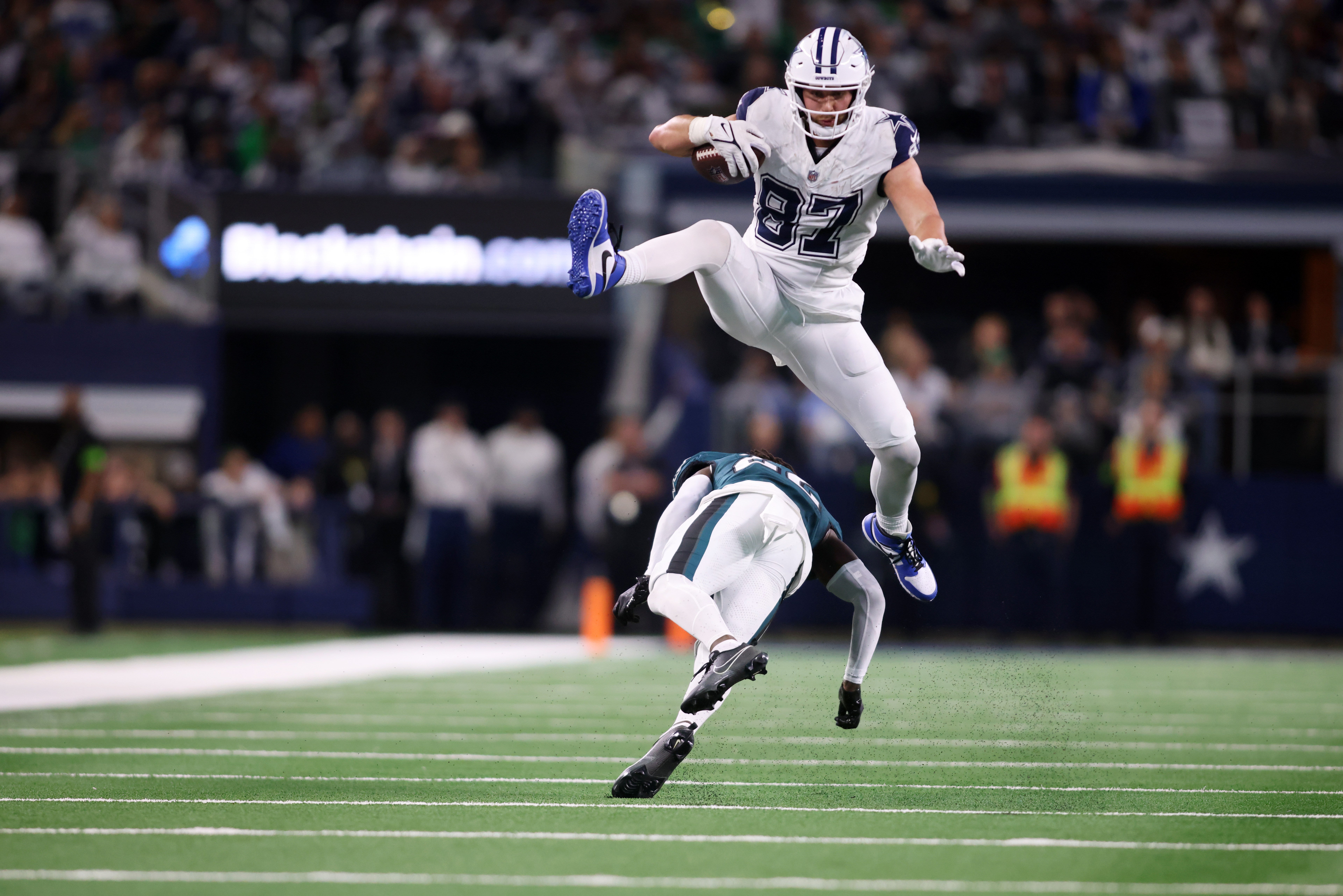 Dallas Cowboys tight end Jake Ferguson (87) jumps over Philadelphia Eagles cornerback Kelee Ringo (22) in the fourth quarter at AT&T Stadium.