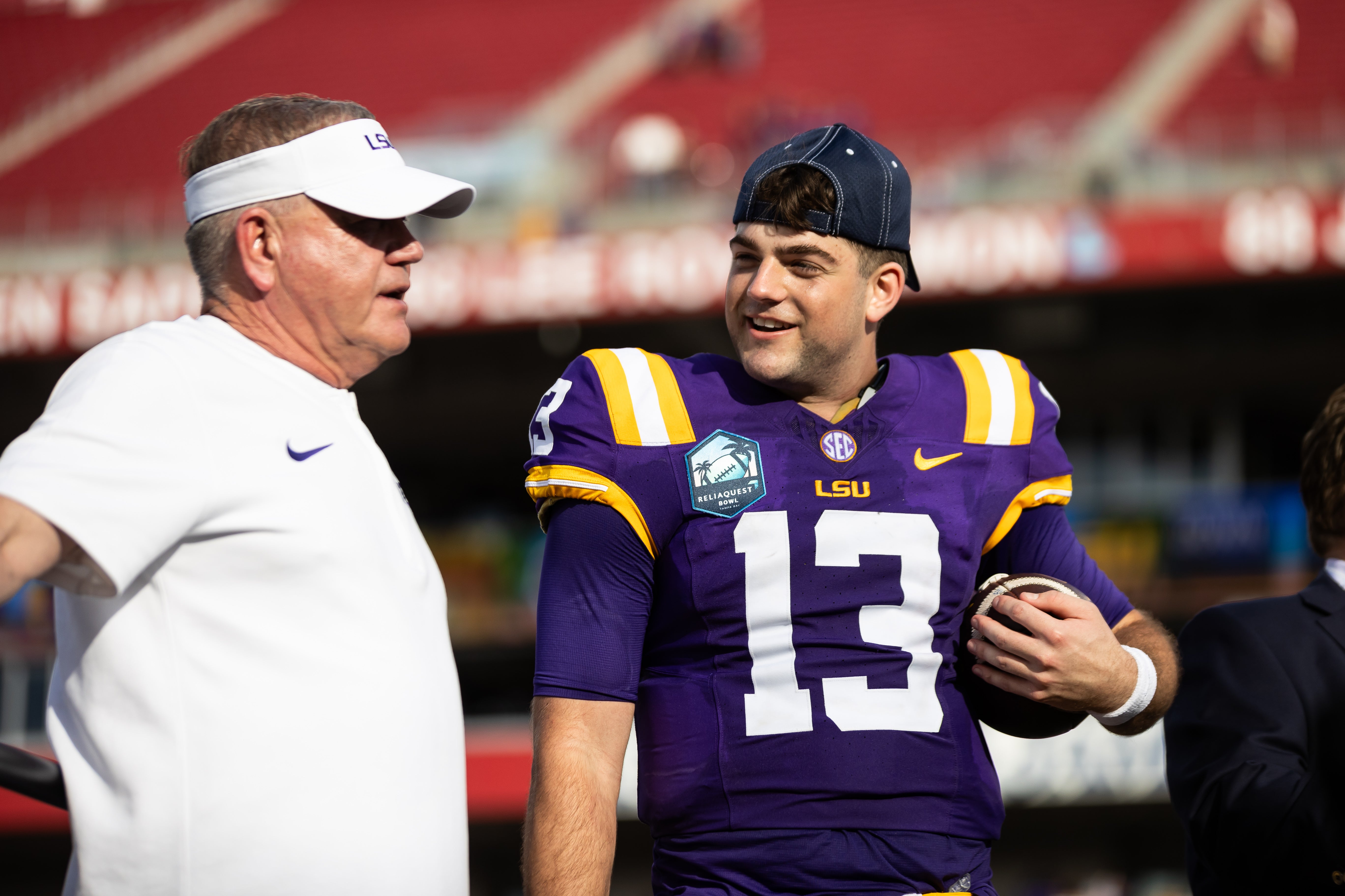 Jan 1, 2024; Tampa, FL, USA; LSU Tigers head coach Brian Kelly and quarterback Garrett Nussmeier (13) talk on the podium after the game against the Wisconsin Badgers at the Reliaquest Bowl at Raymond James Stadium.