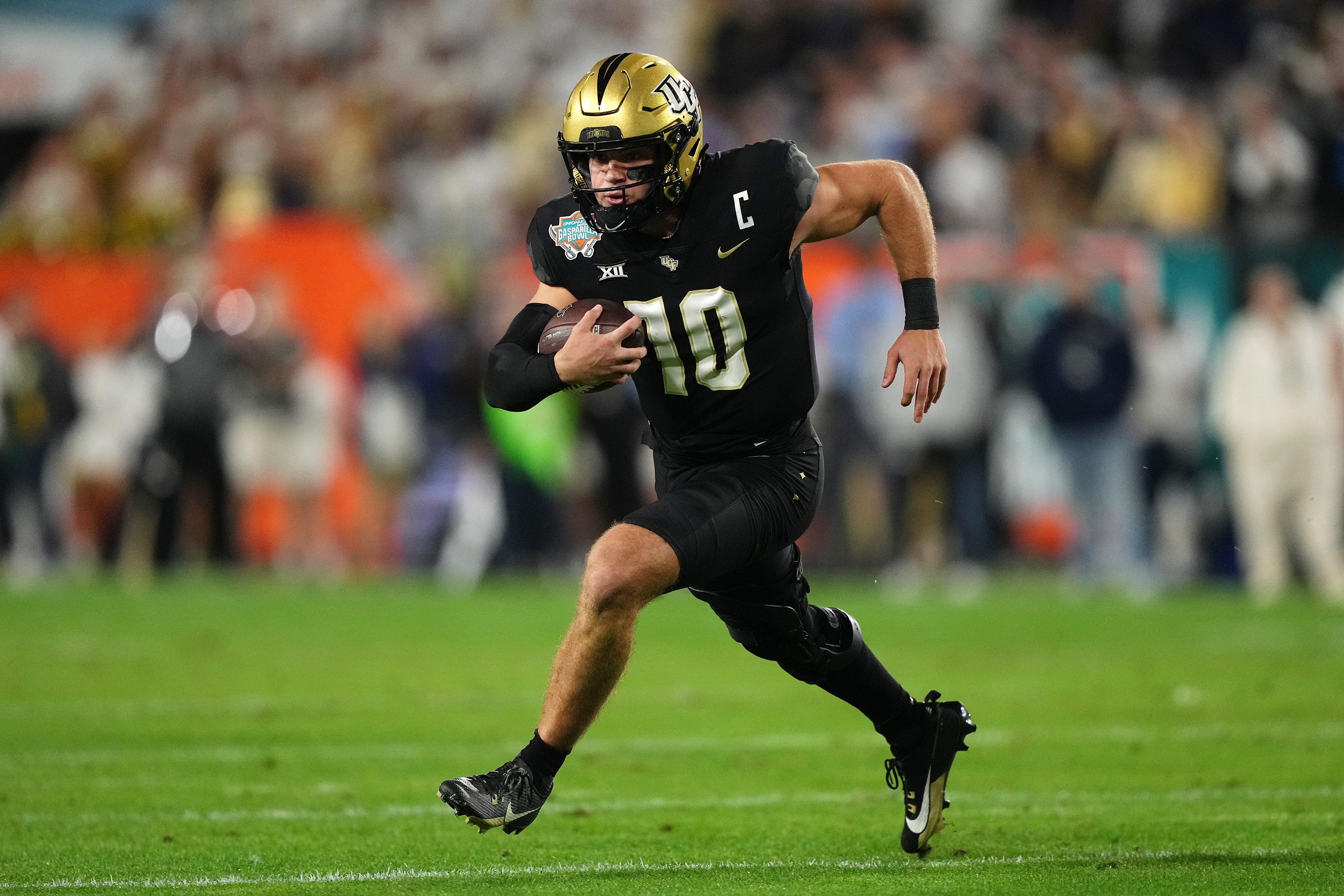 Dec 22, 2023; Tampa, FL, USA; UCF Knights quarterback John Rhys Plumlee (10) runs with the ball during the first half of the Gasparilla Bowl against the Georgia Tech Yellow Jackets at Raymond James Stadium. Mandatory Credit: Jasen Vinlove-USA TODAY Sports  