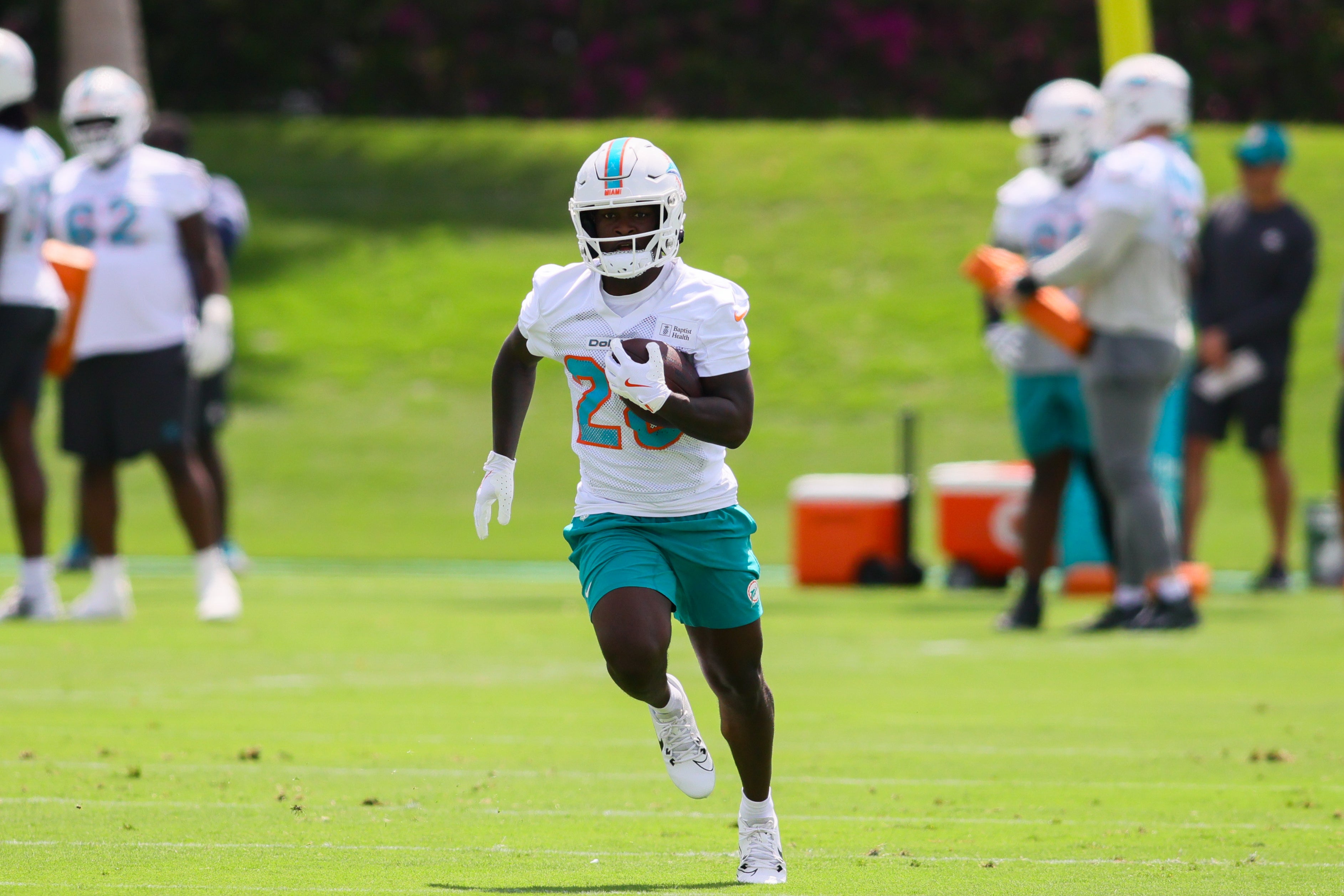 Jun 4, 2024; Miami Gardens, FL, USA; Miami Dolphins running back De'Von Achane (28) runs with the football during mandatory minicamp at Baptist Health Training Complex.