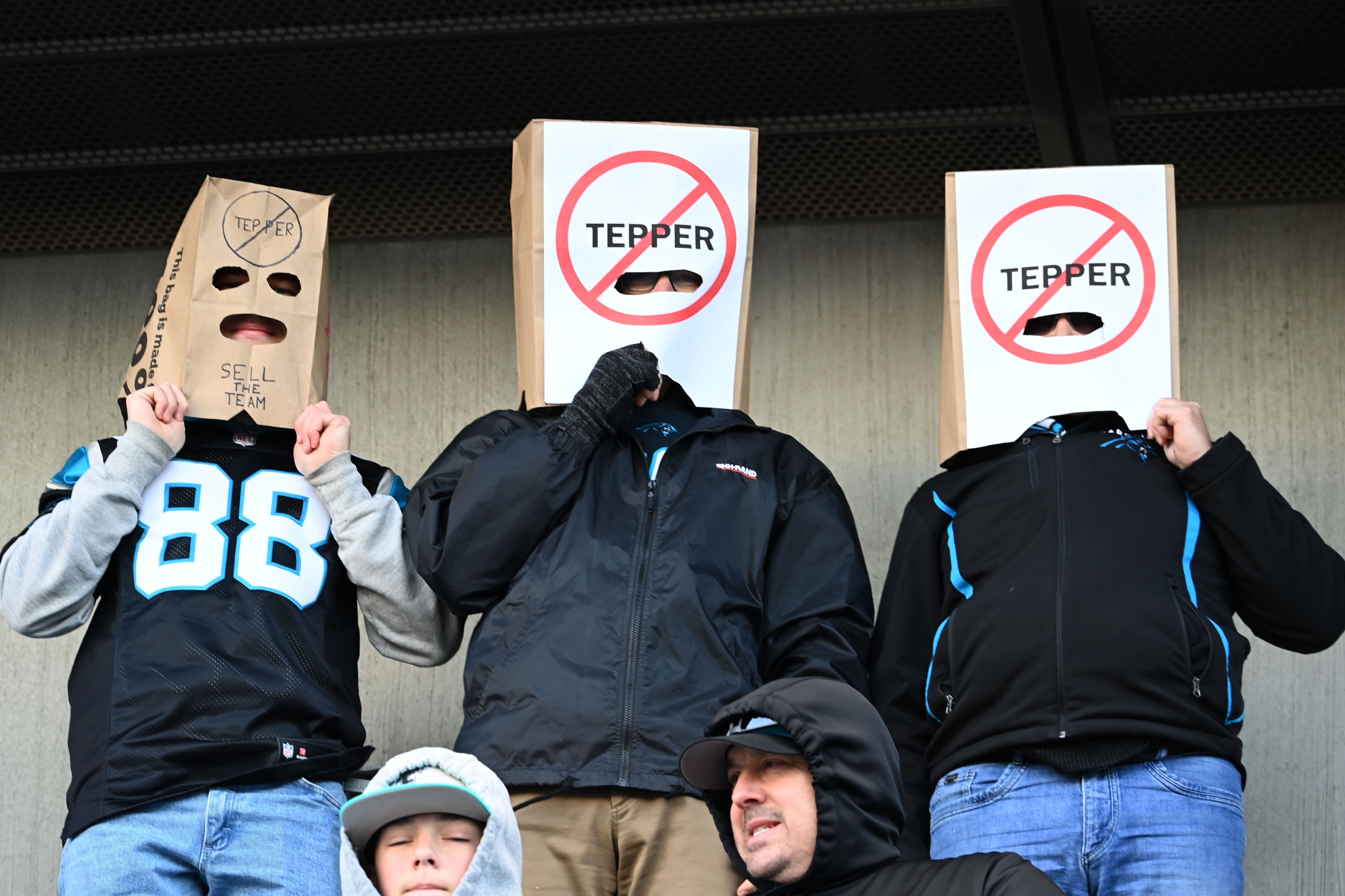 Jan 7, 2024; Charlotte, North Carolina, USA; Carolina Panthers fans Alex Alday, John Alday, and Jon Yonke of Charlotte express their displeasure with Panthers owner David Tepper at Bank of America Stadium. Mandatory Credit: Bob Donnan-USA TODAY Sports