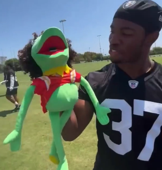 Raiders S Trey Taylor mocks Chiefs QB Patrick Mahomes with a puppet given to him by a fan at training camp.