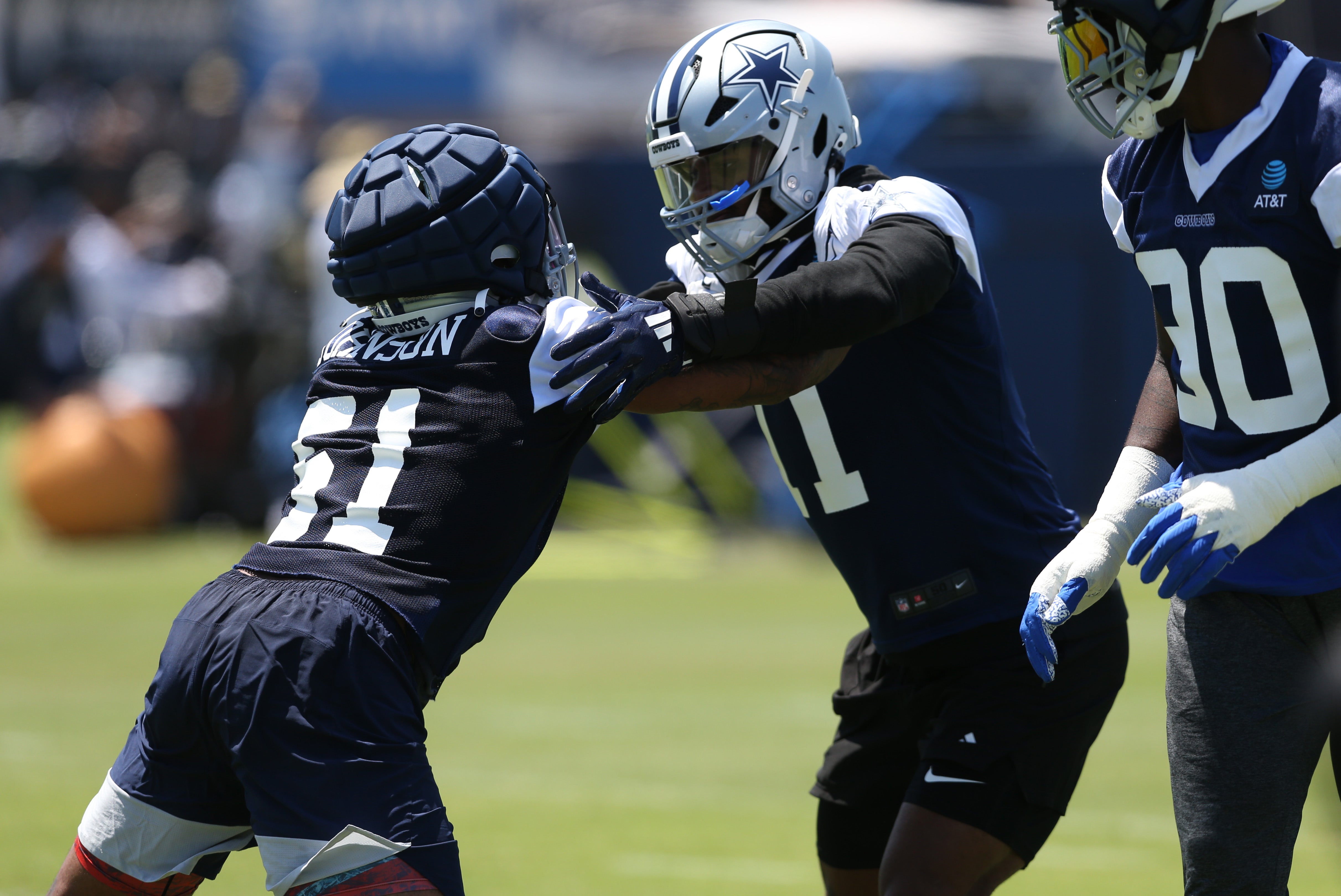 Dallas Cowboys defensive end Durrell Johnson (51) and linebacker Micah Parsons (11) block during training camp at the River Ridge Playing Fields in Oxnard, California.