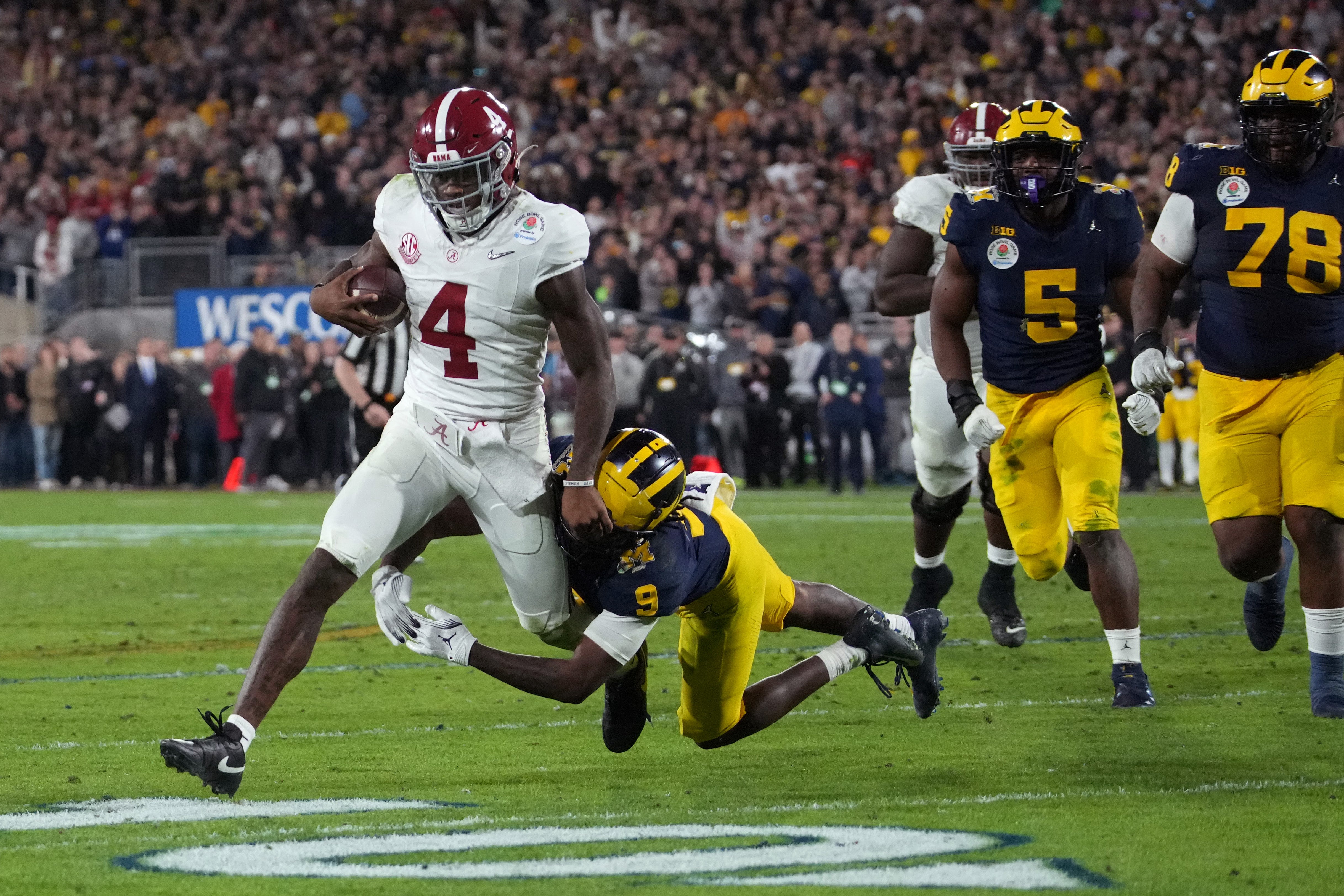 Jan 1, 2024; Pasadena, CA, USA; Alabama Crimson Tide quarterback Jalen Milroe (4) is tackled by Michigan Wolverines defensive back Rod Moore (9) during overtime in the 2024 Rose Bowl college football playoff semifinal game at Rose Bowl. Mandatory Credit: Kirby Lee-USA TODAY Sports