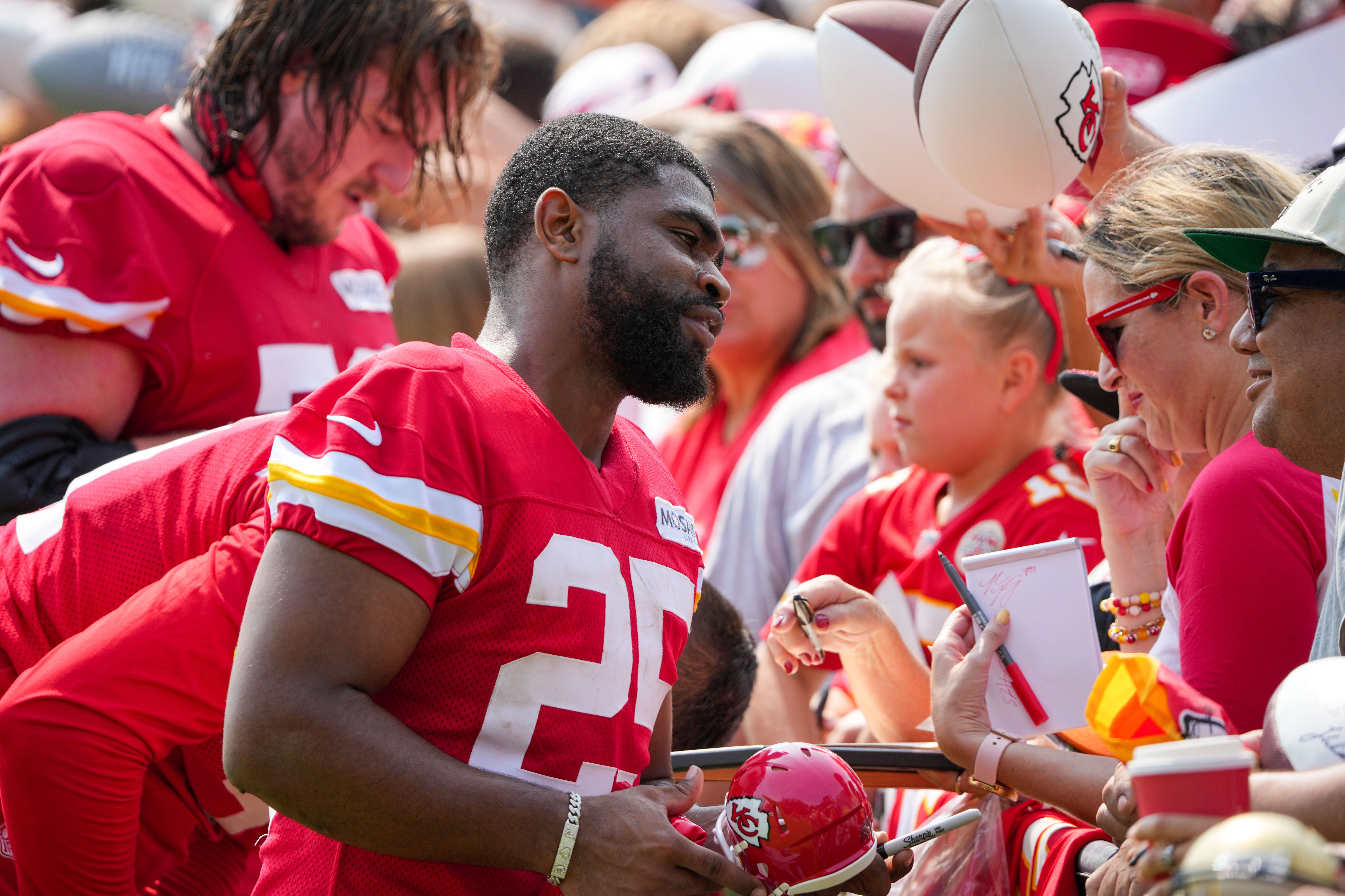Jul 22, 2024; St. Joseph, MO, USA; Kansas City Chiefs running back Clyde Edwards-Helaire (25) signs autographs for fans after training camp at Missouri Western State University.