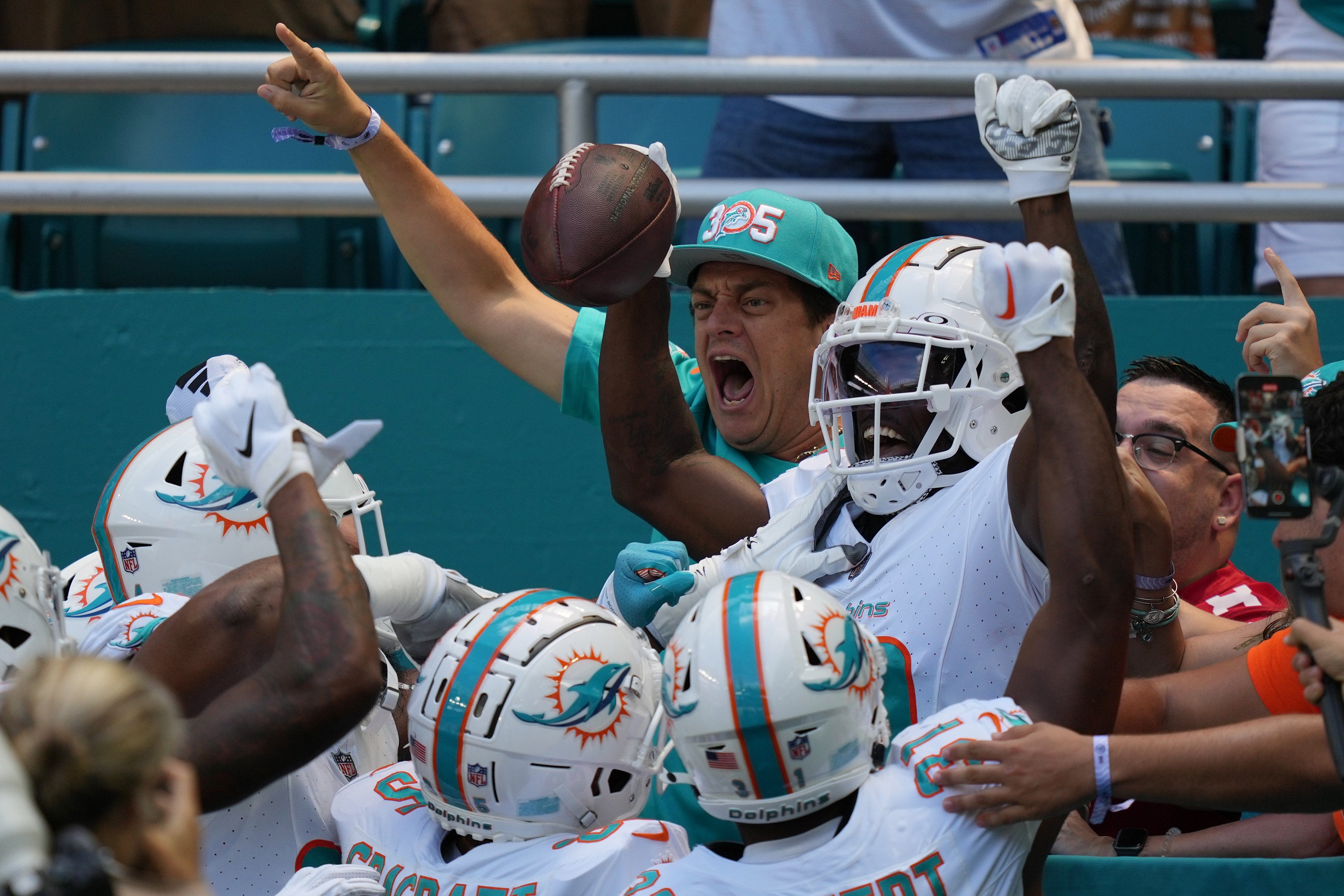 Miami Dolphins wide receiver Tyreek Hill (10) celebrates scoring a touchdown against the Denver Broncos during the first half of an NFL game from the stands at Hard Rock Stadium in Miami Gardens, Sept. 24, 2023.