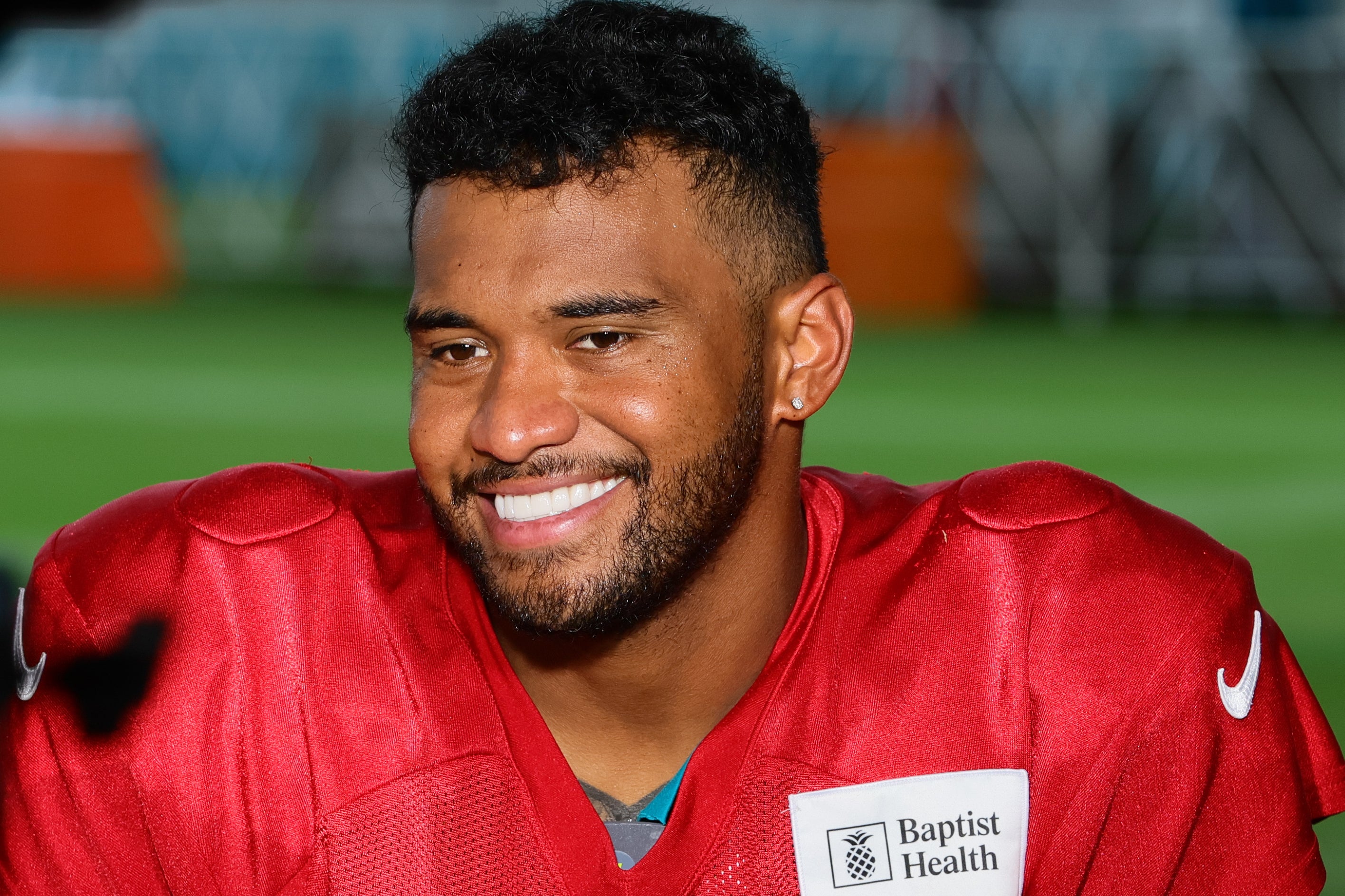 Jul 29, 2024; Miami Gardens, FL, USA; Miami Dolphins quarterback Tua Tagovailoa (1) reacts while talking to reporters during an interview after training camp at Baptist Health Training Complex.
