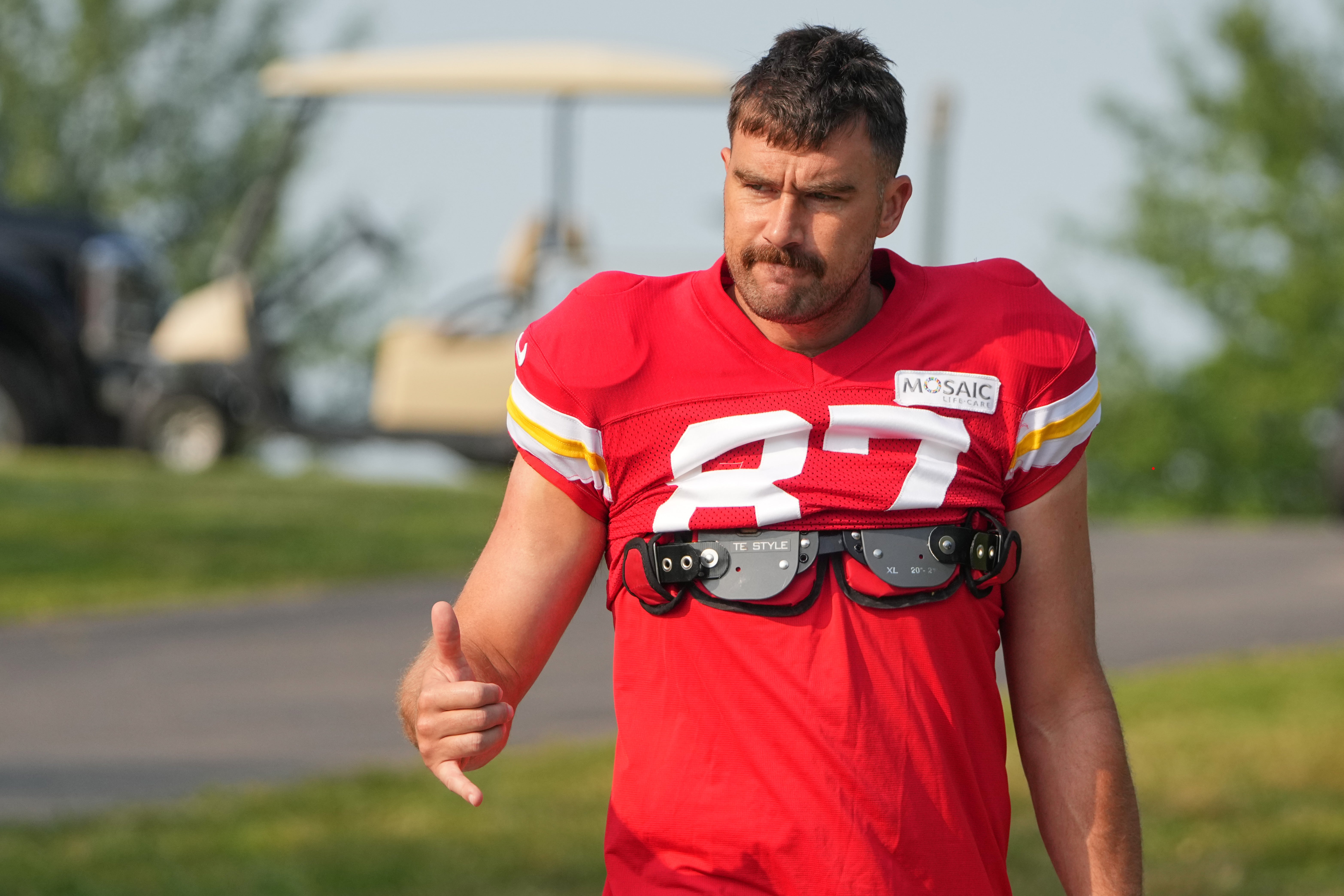Jul 26, 2024; Kansas City, MO, USA; Kansas City Chiefs tight end Travis Kelce (87) waves to fans as he walks down the hill from the locker room to the fields prior to training camp at Missouri Western State University.