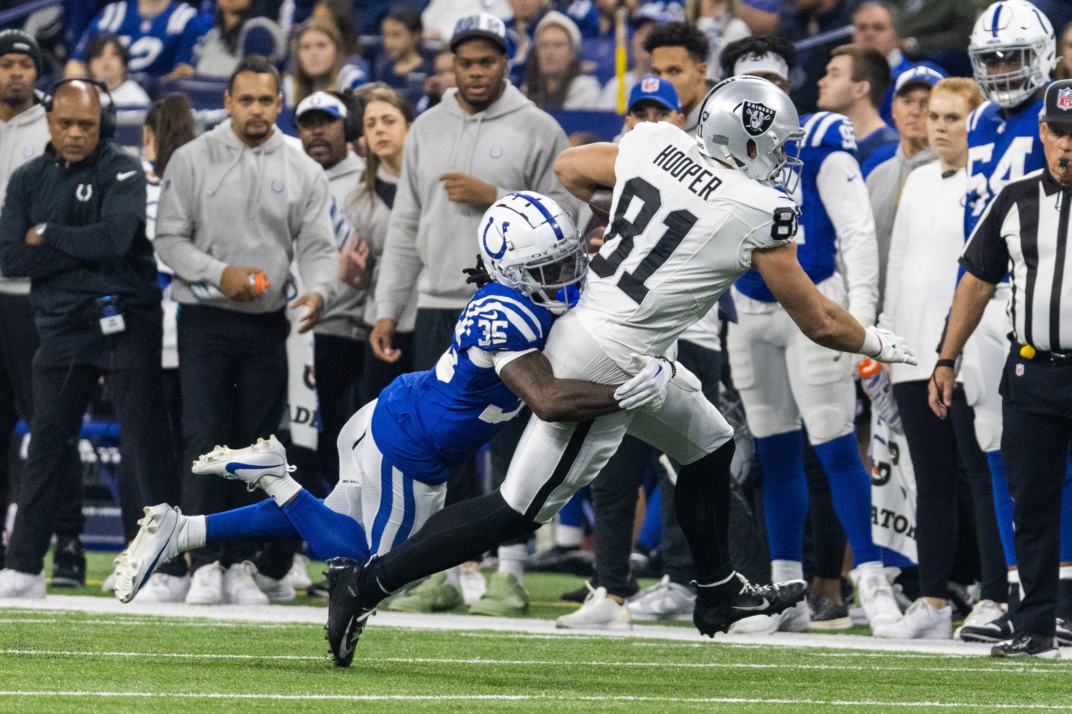 Dec 31, 2023; Indianapolis, Indiana, USA; Las Vegas Raiders tight end Austin Hooper (81) runs with the ball after a catch while Indianapolis Colts cornerback Chris Lammons (35) defends in the first half at Lucas Oil Stadium.