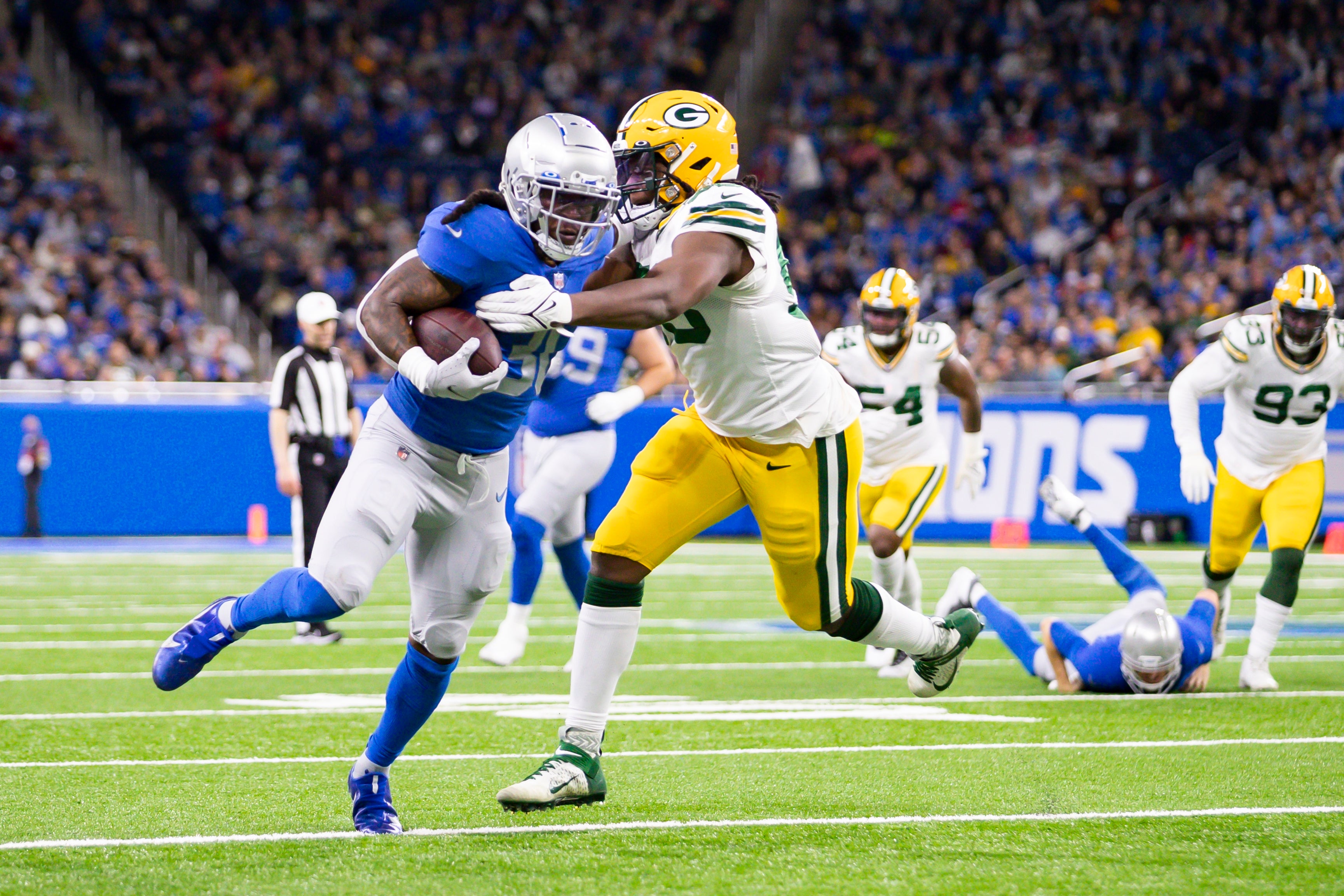 Jan 9, 2022; Detroit, Michigan, USA; Detroit Lions running back Jamaal Williams (30) runs the ball against Green Bay Packers linebacker Jonathan Garvin (53) during the fourth quarter at Ford Field.