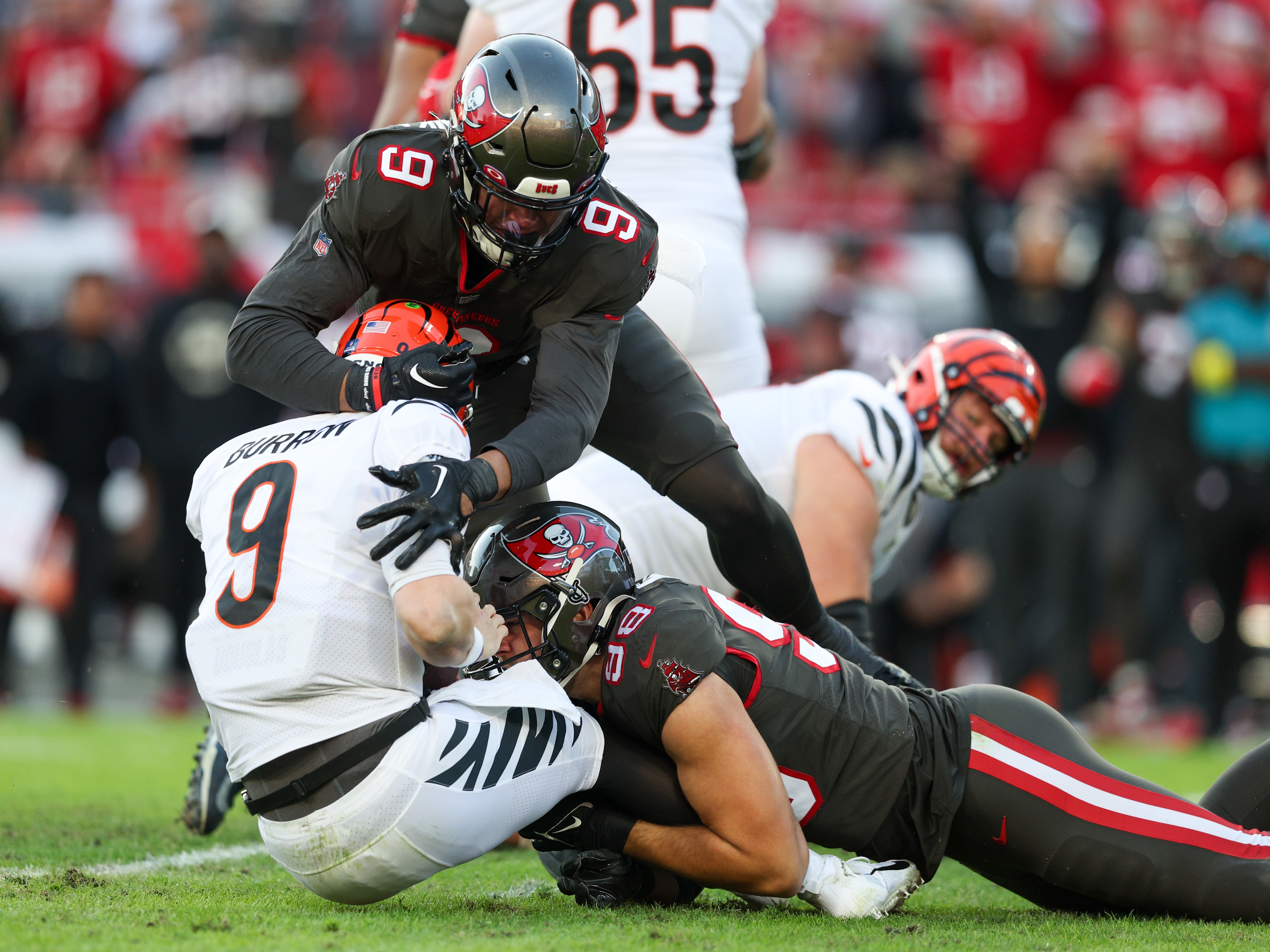 Dec 18, 2022; Tampa, Florida, USA; Cincinnati Bengals quarterback Joe Burrow (9) is sacked by Tampa Bay Buccaneers linebacker Anthony Nelson (98) and Tampa Bay Buccaneers linebacker Joe Tryon-Shoyinka (9) in the first quarter at Raymond James Stadium.