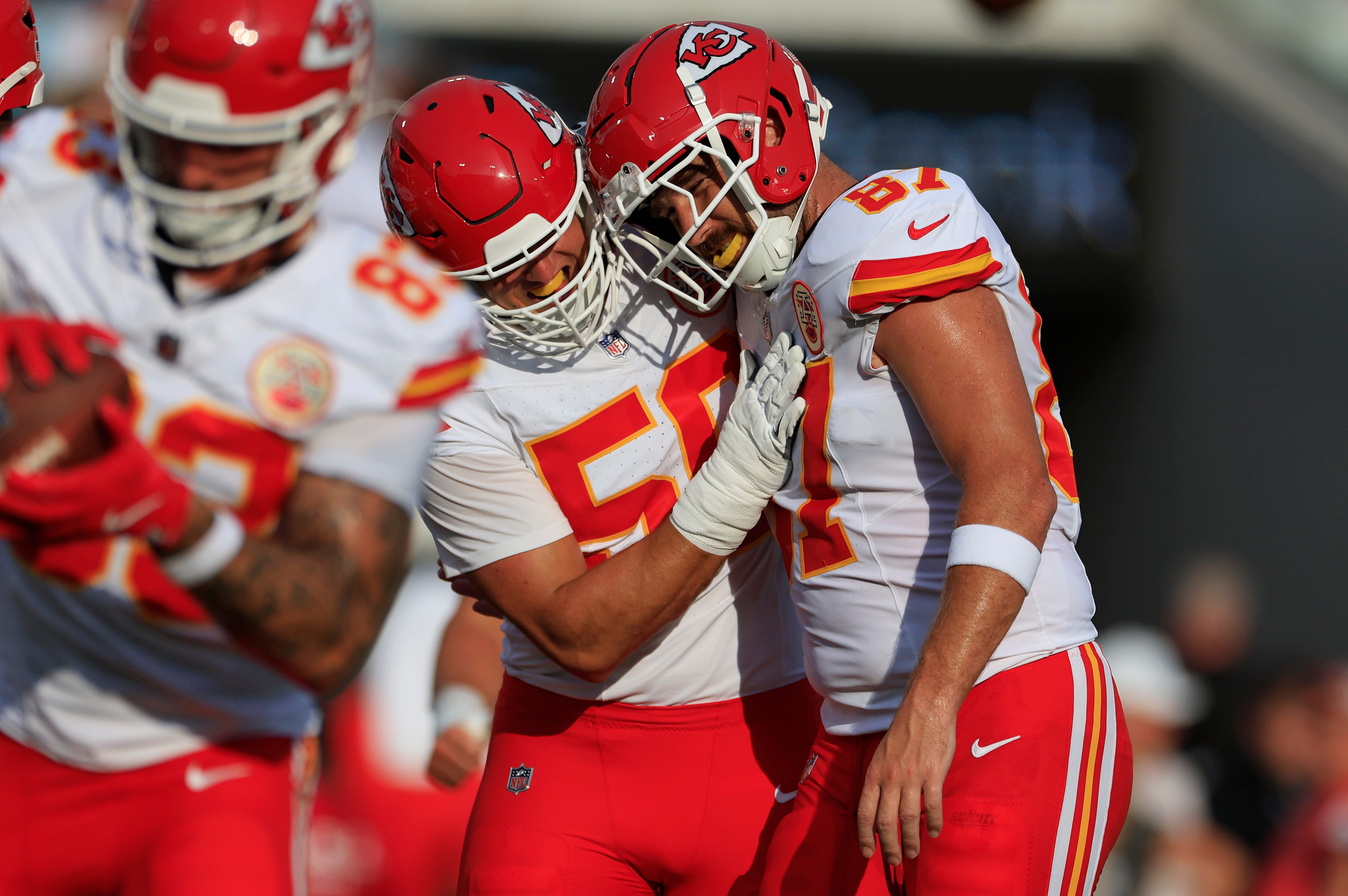Kansas City Chiefs defensive end George Karlaftis (56) hugs tight end Travis Kelce (87) before a preseason NFL football game Saturday, Aug. 10, 2024 at EverBank Stadium in Jacksonville, Fla.