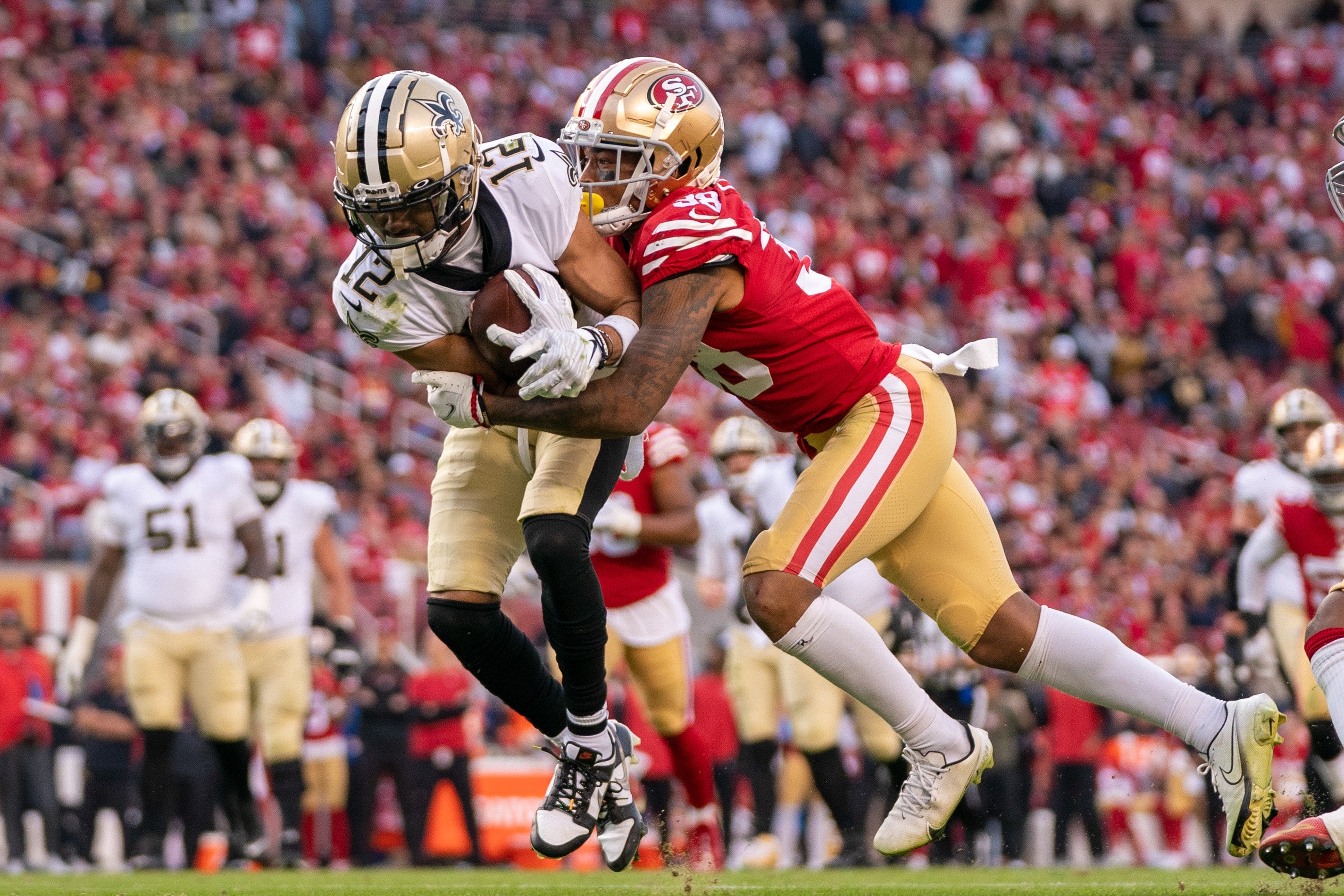 November 27, 2022; Santa Clara, California, USA; New Orleans Saints wide receiver Chris Olave (12) is tackled by San Francisco 49ers cornerback Deommodore Lenoir (38) during the fourth quarter at Levi's Stadium.