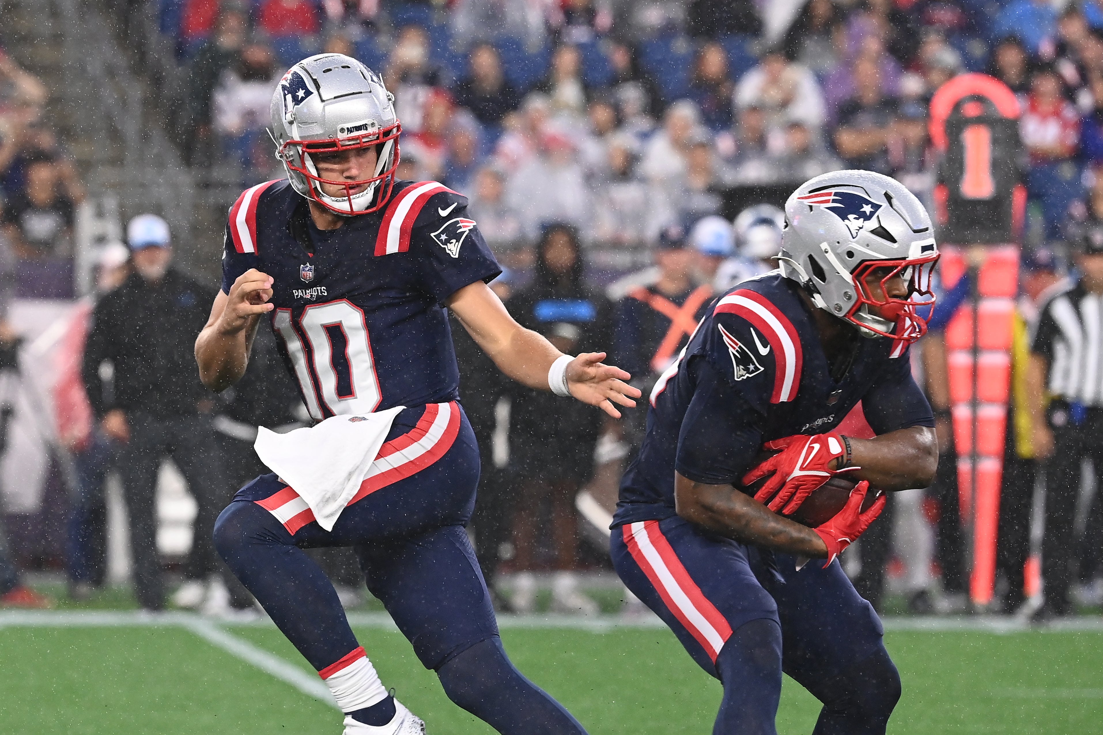 August 8, 2024; Foxborough, MA, USA; New England Patriots quarterback Drake Maye (10) hands the ball to running back Antonio Gibson (21) during the first half against the Carolina Panthers at Gillette Stadium.