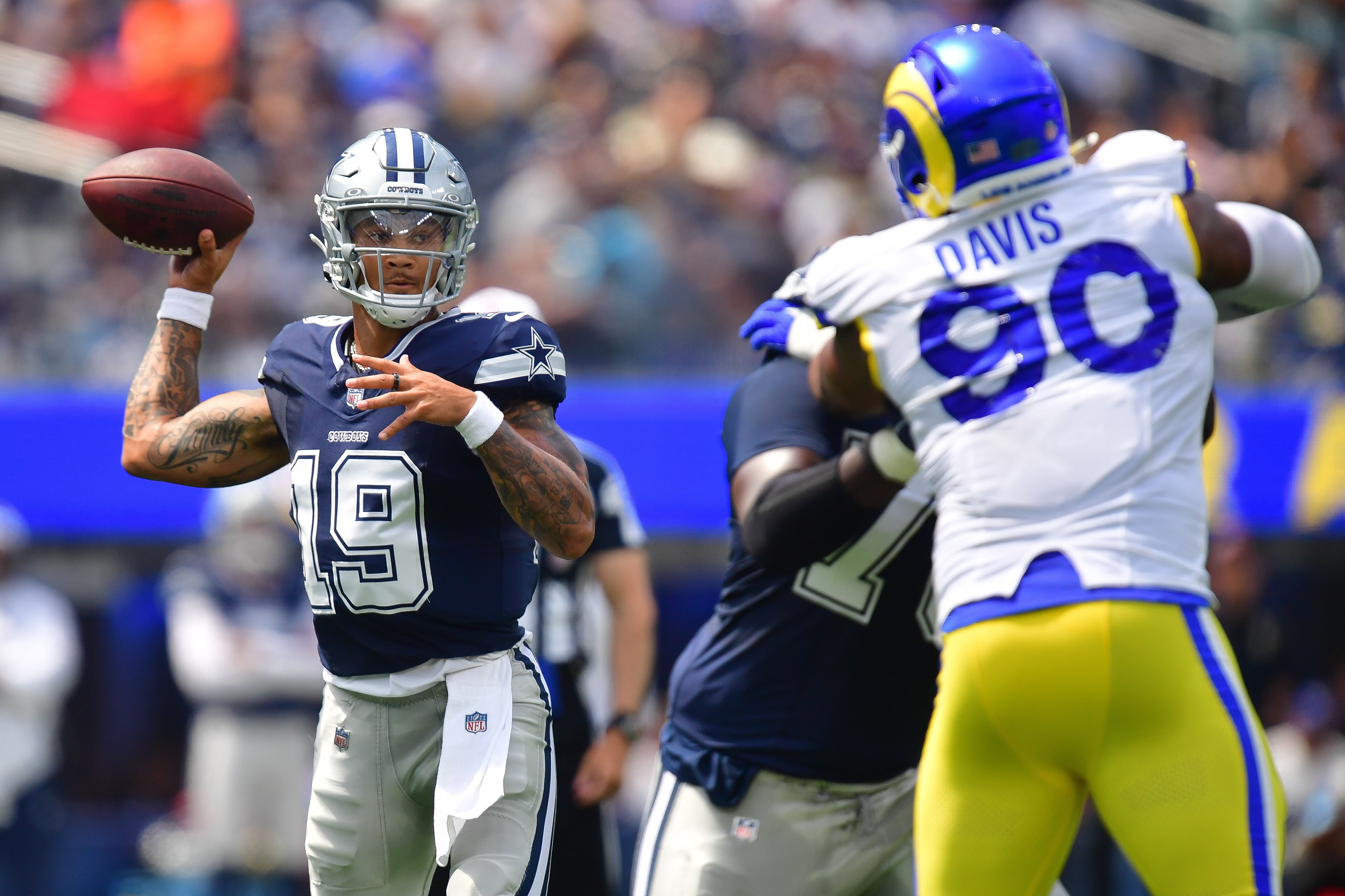 Dallas Cowboys quarterback Trey Lance (19) throws under pressure from Los Angeles Rams defensive tackle Tyler Davis (90) during the first half at SoFi Stadium.