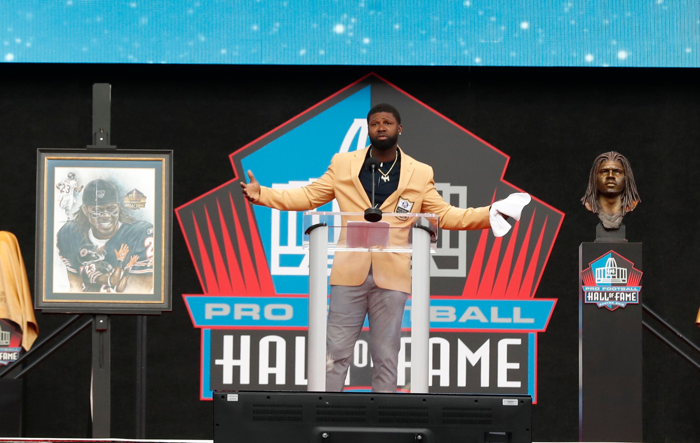 Aug 3, 2024; Canton, OH, USA; Class of 2024 member Devin Hester gestures during his acceptance speech into the Pro Football Hall of Fame at the enshrinement ceremony at Tom Benson Hall of Fame Stadium.