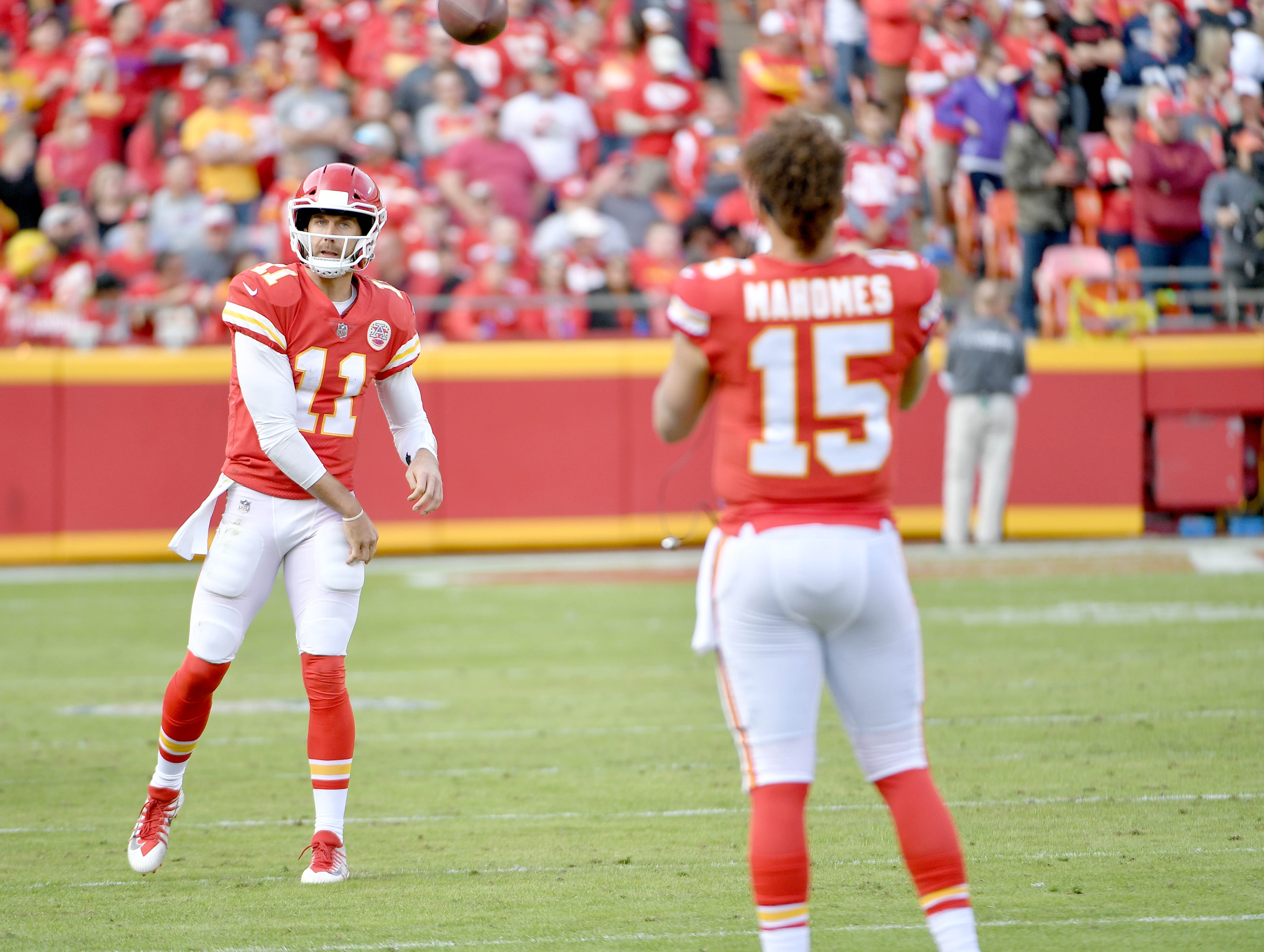 Nov 26, 2017; Kansas City, MO, USA; Kansas City Chiefs quarterback Alex Smith (11) throws passes to quarterback Patrick Mahomes (15) on the sidelines during the second half against the Buffalo Bills at Arrowhead Stadium.