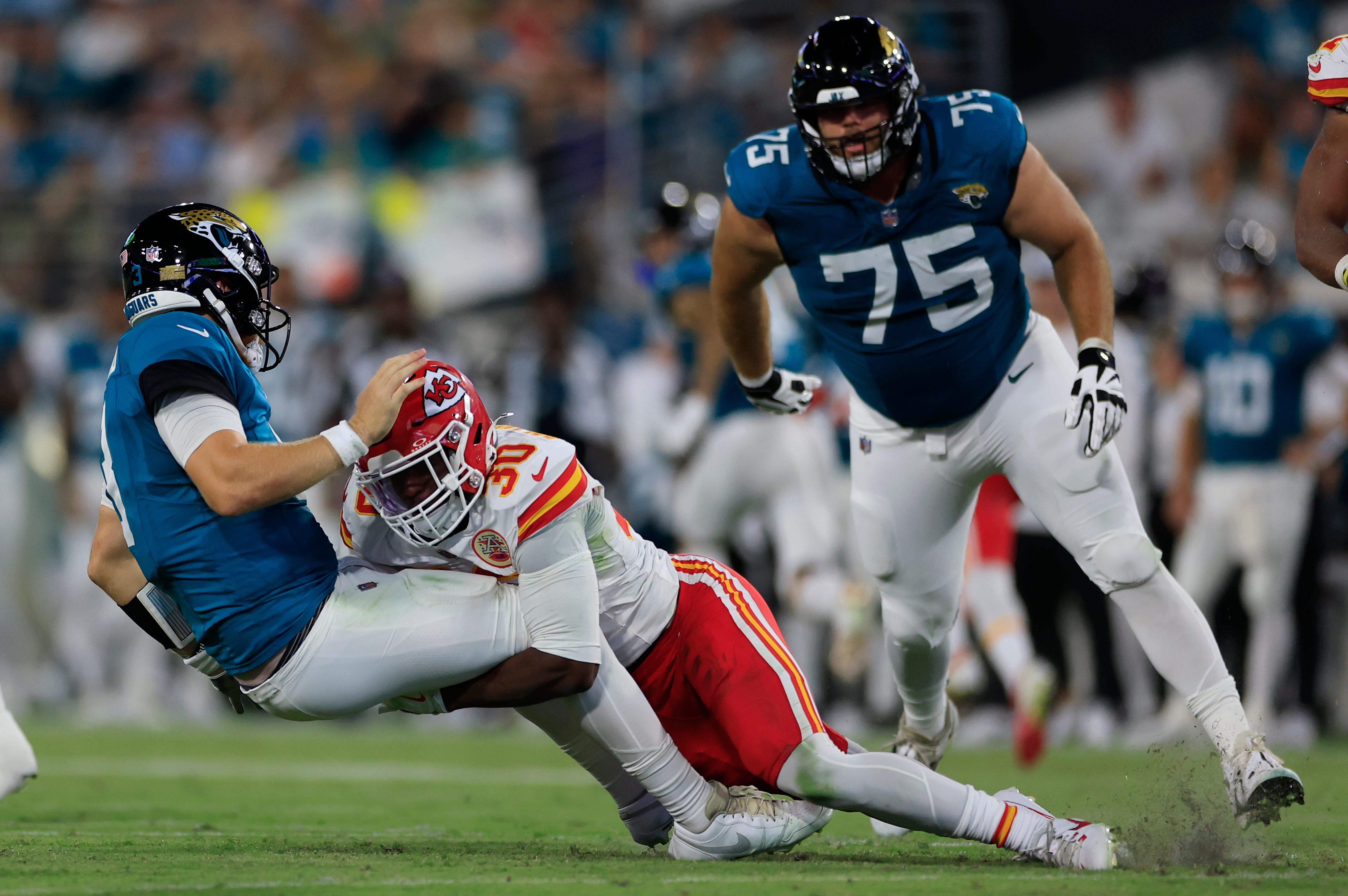 Kansas City Chiefs cornerback Christian Roland-Wallace (30) tackles Jacksonville Jaguars quarterback C.J. Beathard (3) during the second quarter of a preseason NFL football game Saturday, Aug. 10, 2024 at EverBank Stadium in Jacksonville, Fla.