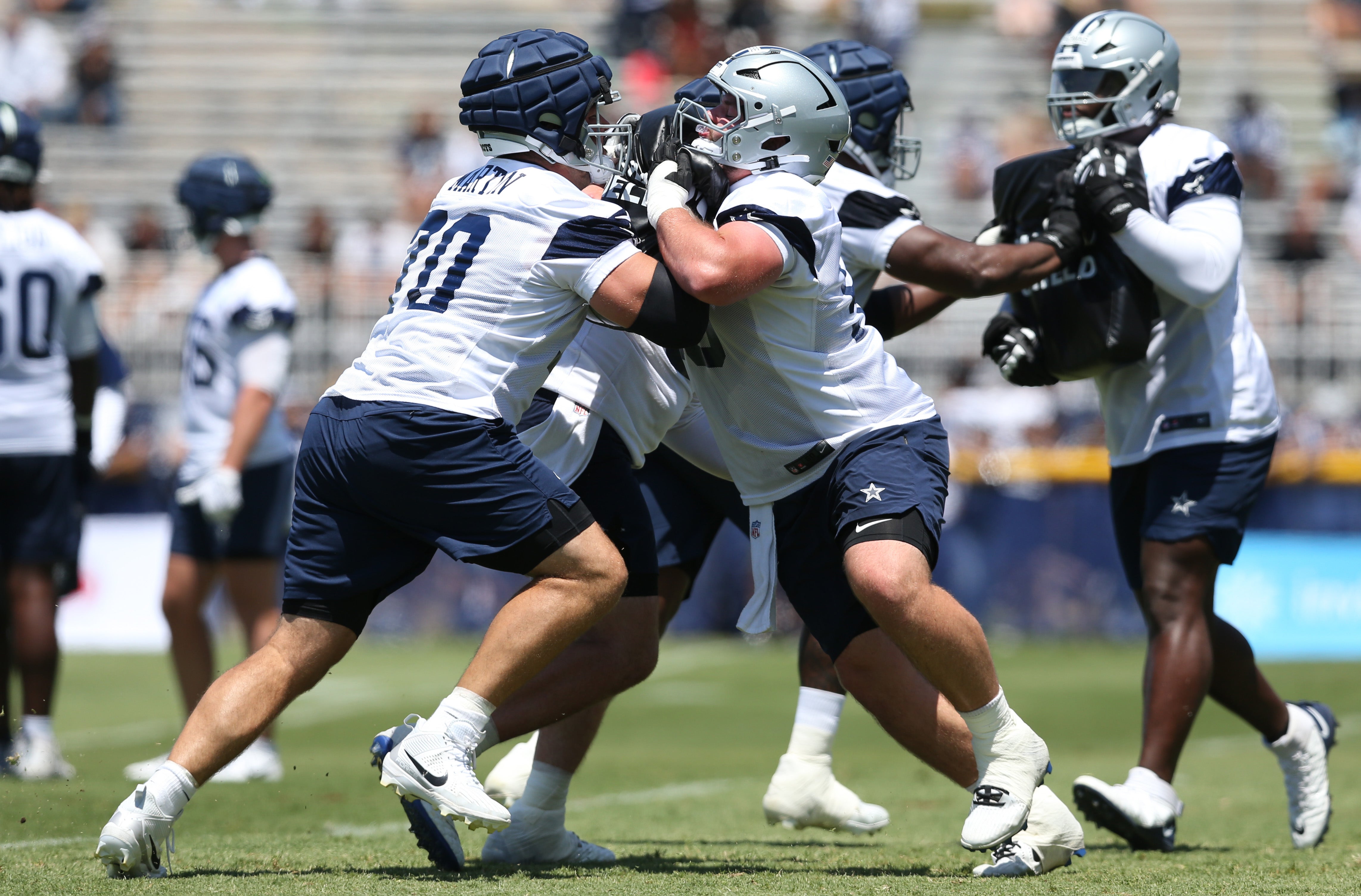 Dallas Cowboys guards Zack Martin (70) and Cooper Beebe (56) block during training camp at the River Ridge Playing Fields in Oxnard, California