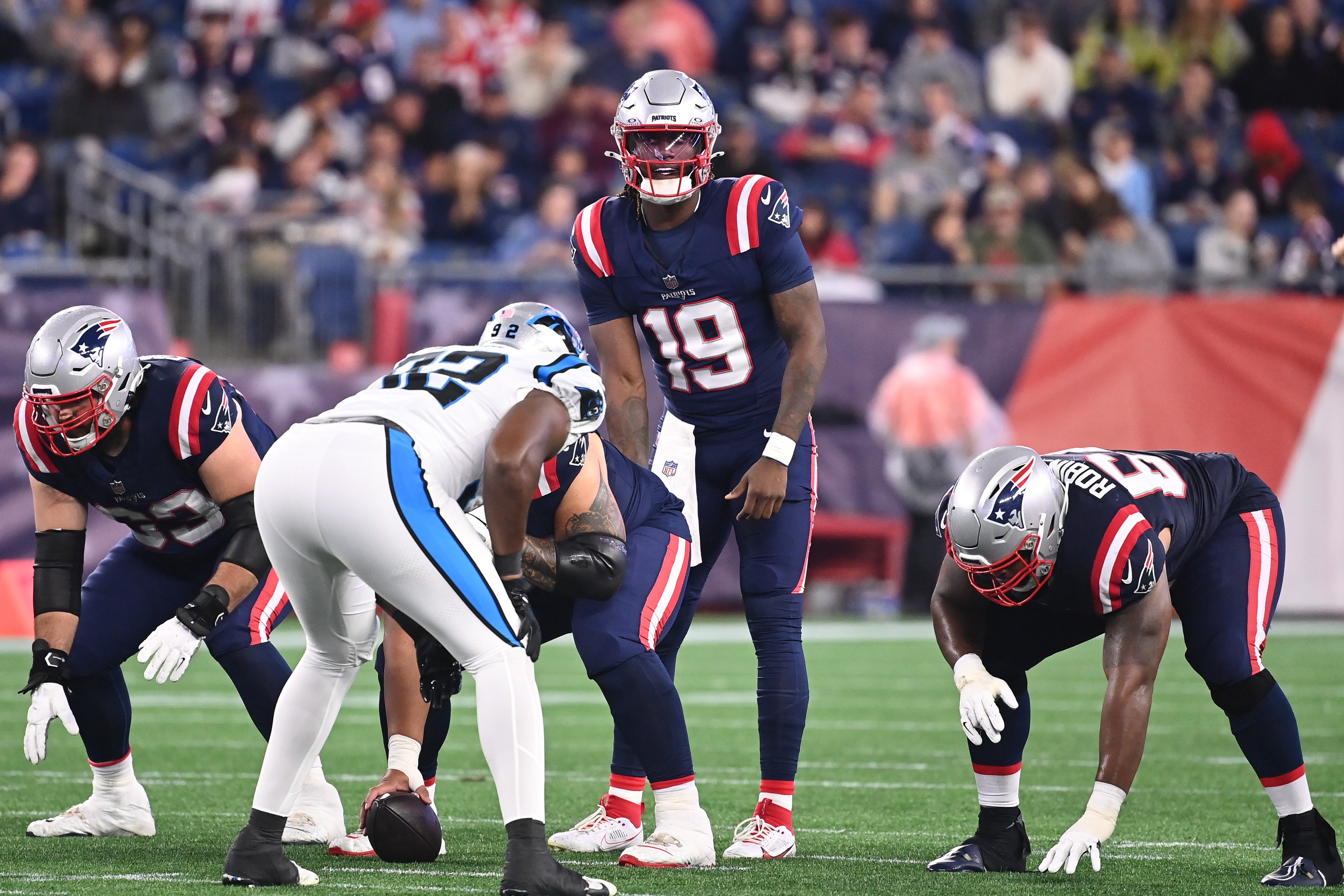 August 8, 2024; Foxborough, MA, USA; New England Patriots quarterback Joe Milton III (19) at the line of scrimmage during the second half against the Carolina Panthers at Gillette Stadium.