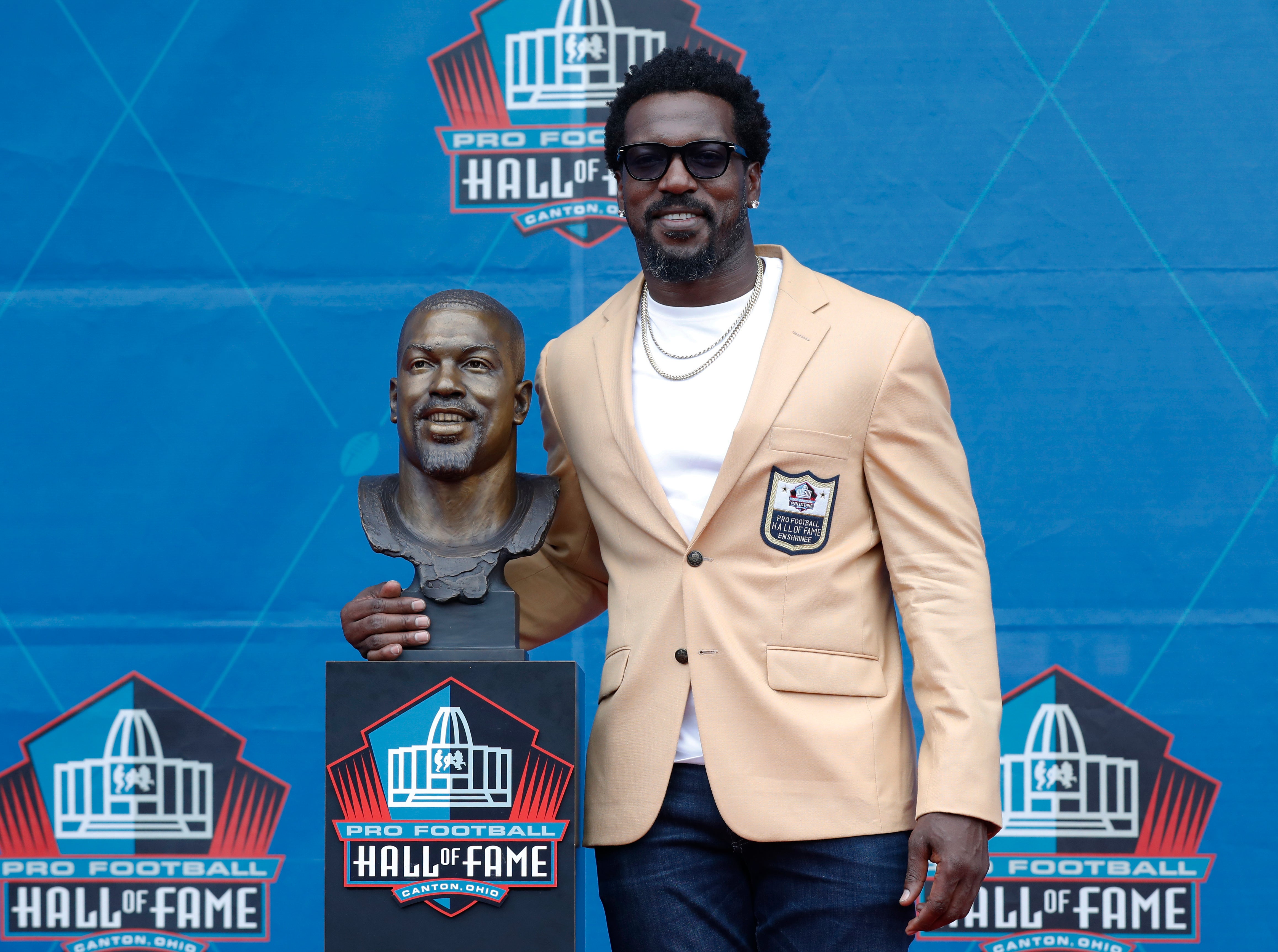 Aug 3, 2024; Canton, OH, USA; Class of 2024 Pro Football member Patrick Willis poses with his bust at the enshrinement ceremony at Tom Benson Hall of Fame Stadium.