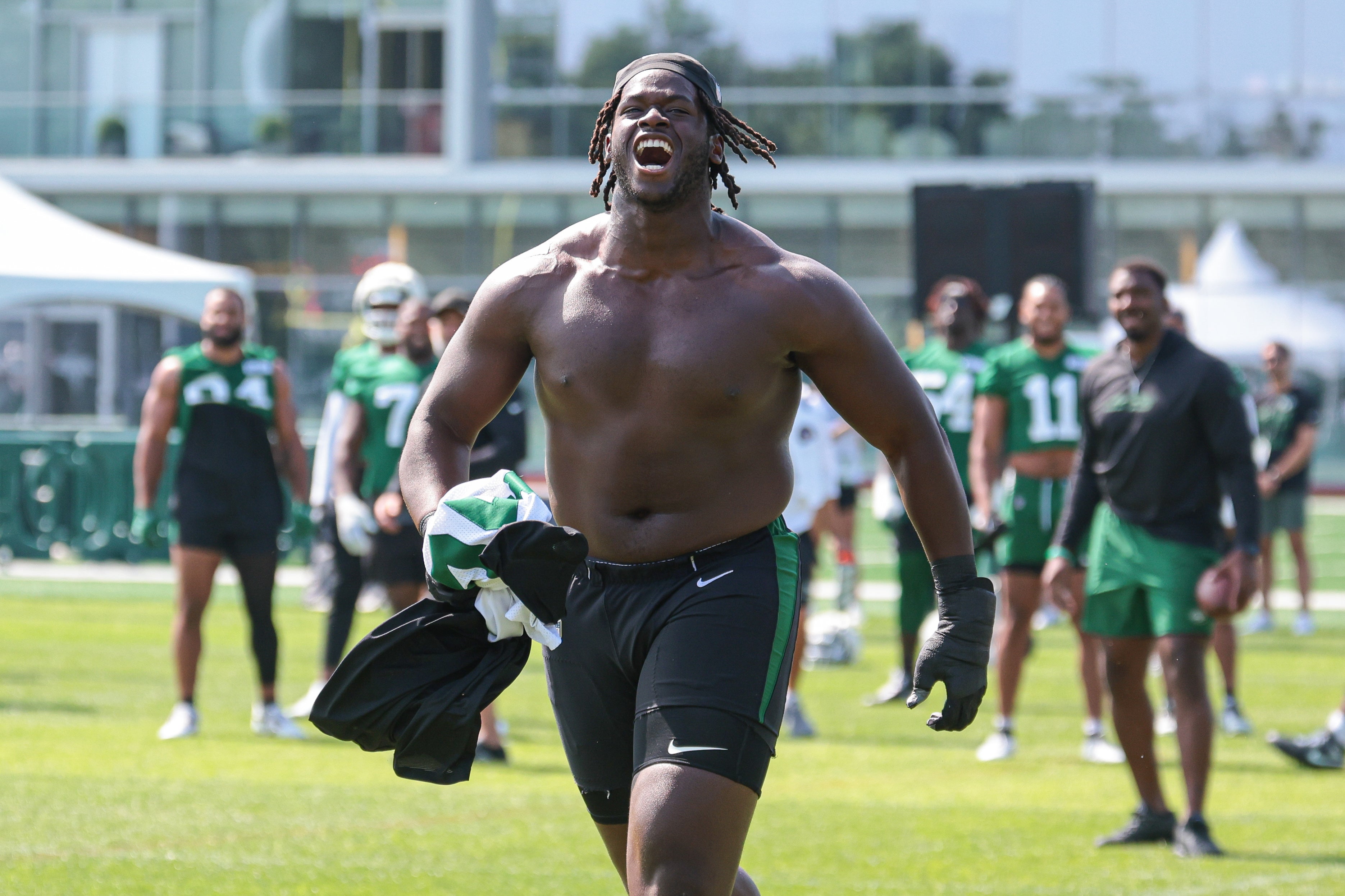 New York Jets offensive tackle Olu Fashanu (74) runs up field greeting fans during training camp at Atlantic Health Jets Training Center.
