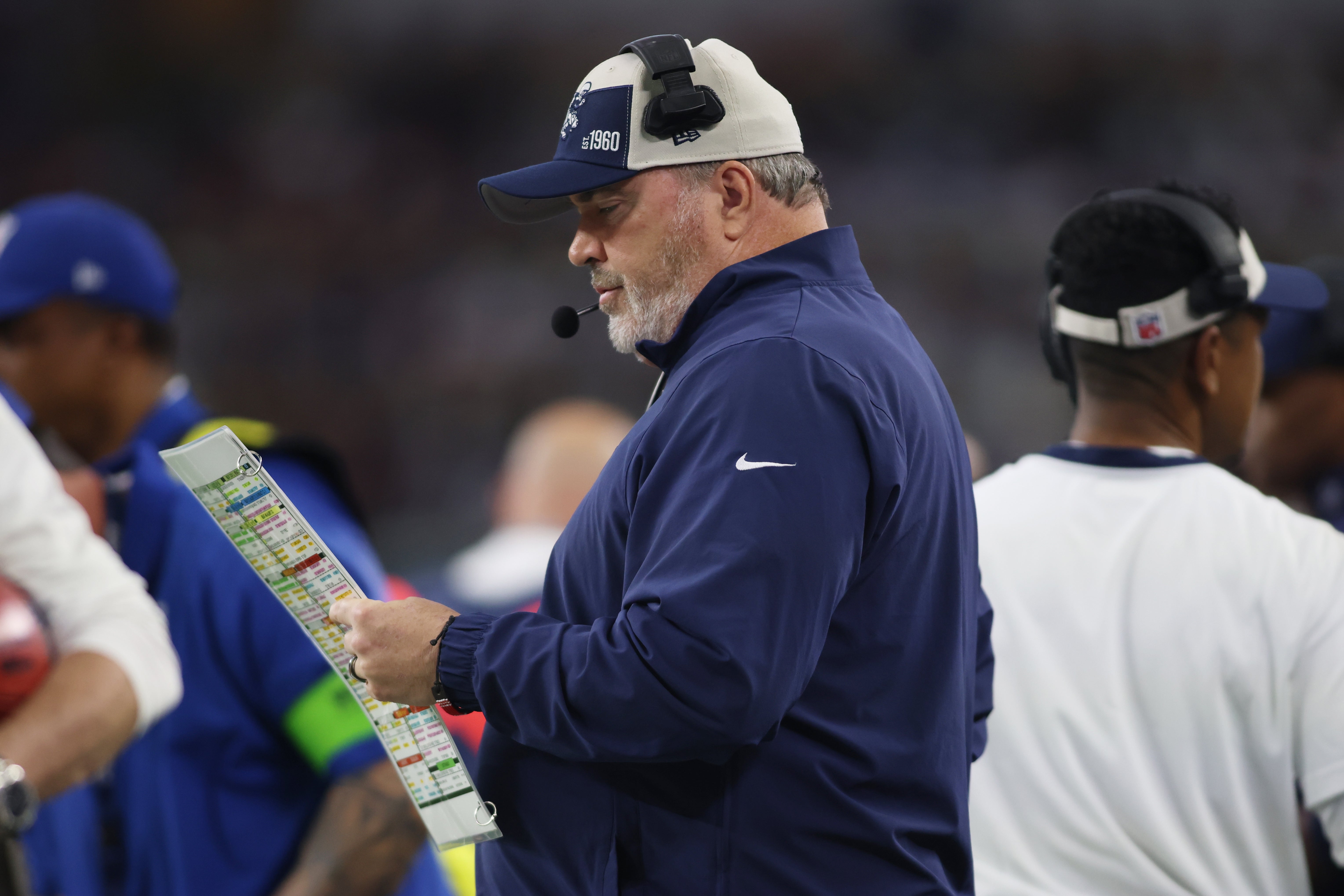 Dallas Cowboys Mike McCarthy looks at the play sheet in then first quarter against the Washington Commanders at AT&T Stadium.