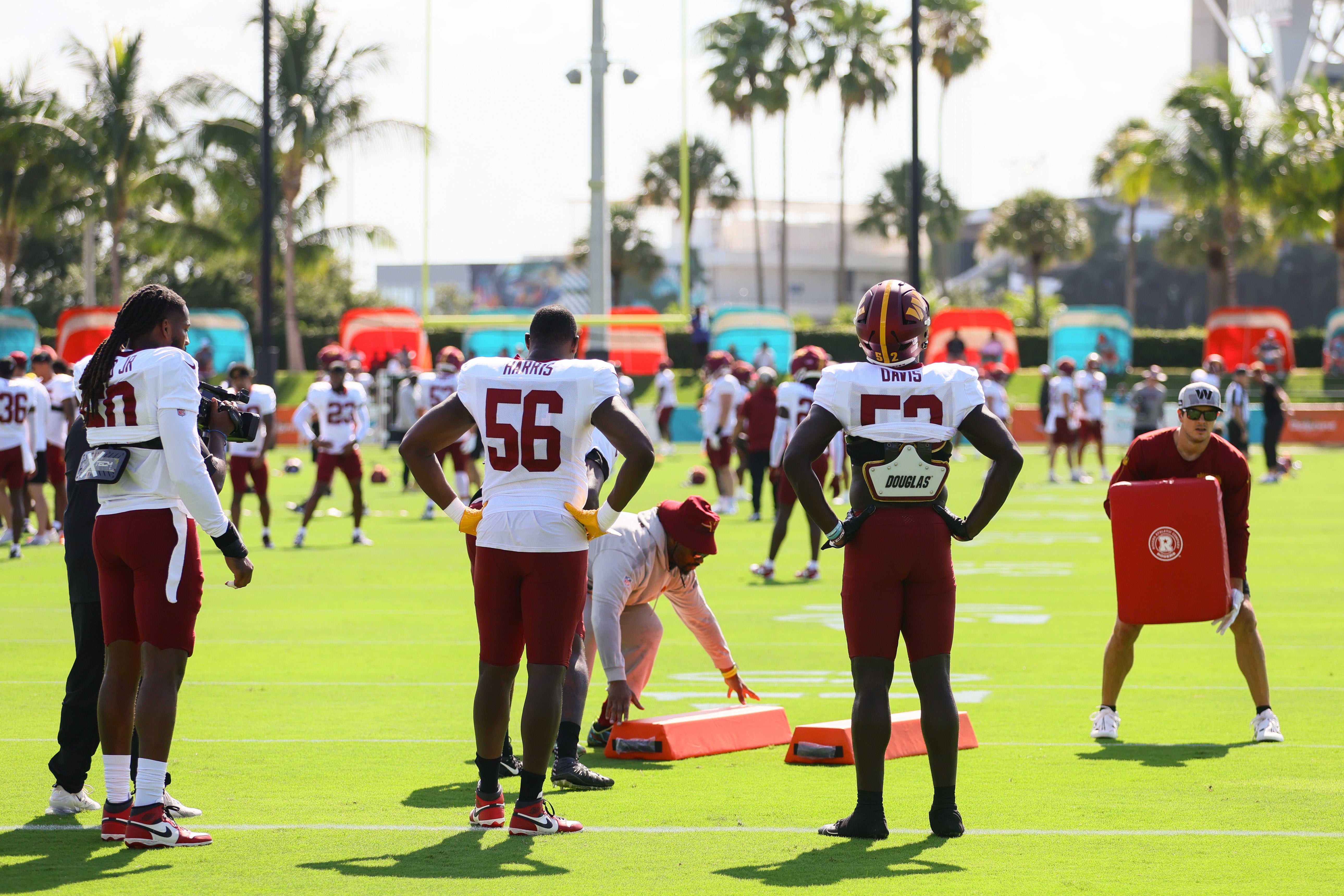 Aug 15, 2024; Miami Gardens, FL, USA; Washington Commanders defensive end Jalen Harris (56) and linebacker Jamin Davis (52) work out during joint practice with the Miami Dolphins at Baptist Health Training Complex.