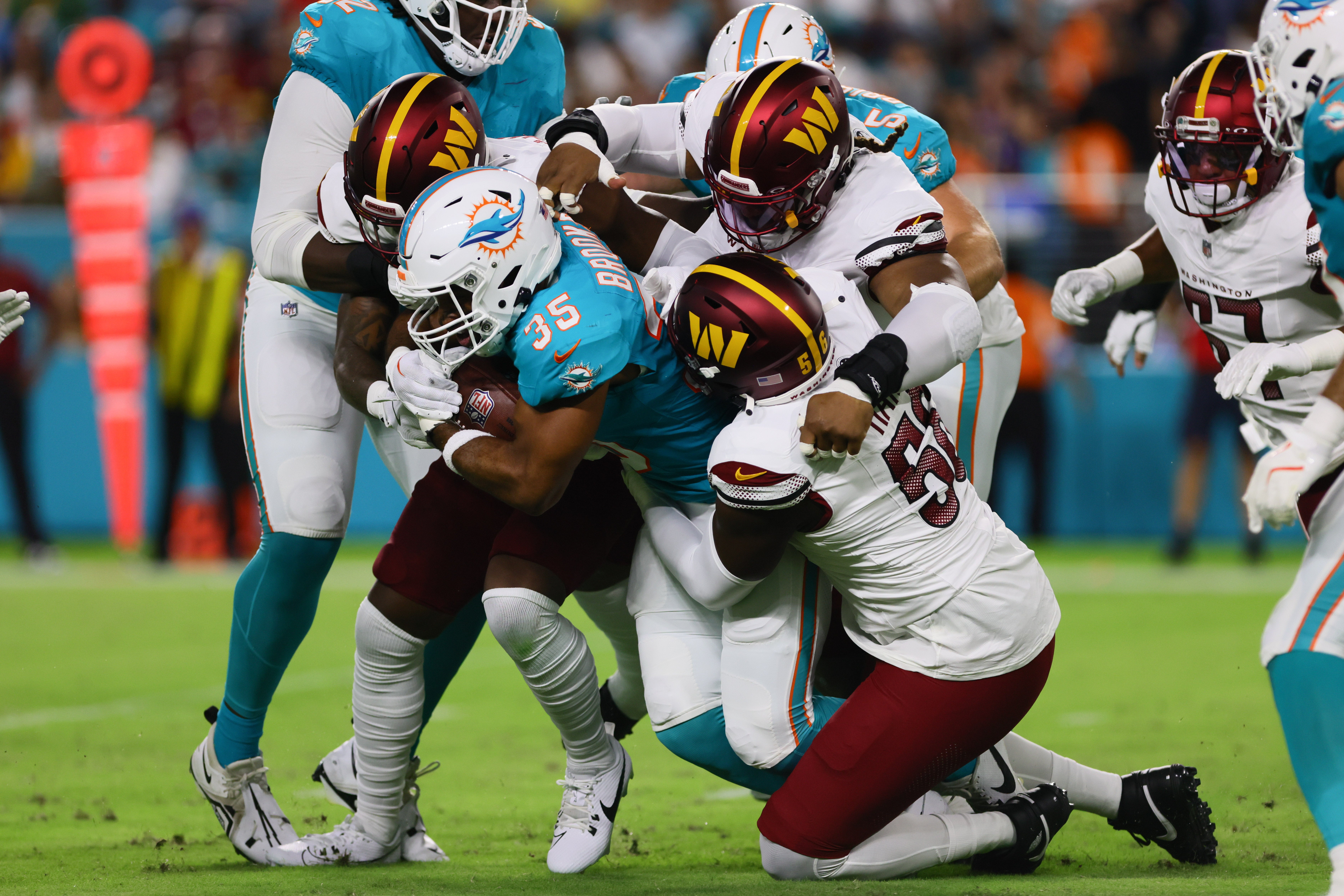 Aug 17, 2024; Miami Gardens, Florida, USA; Miami Dolphins running back Chris Brooks (35) runs with the football against Washington Commanders defensive end Jalen Harris (56) during the second quarter of a preseason game at Hard Rock Stadium.