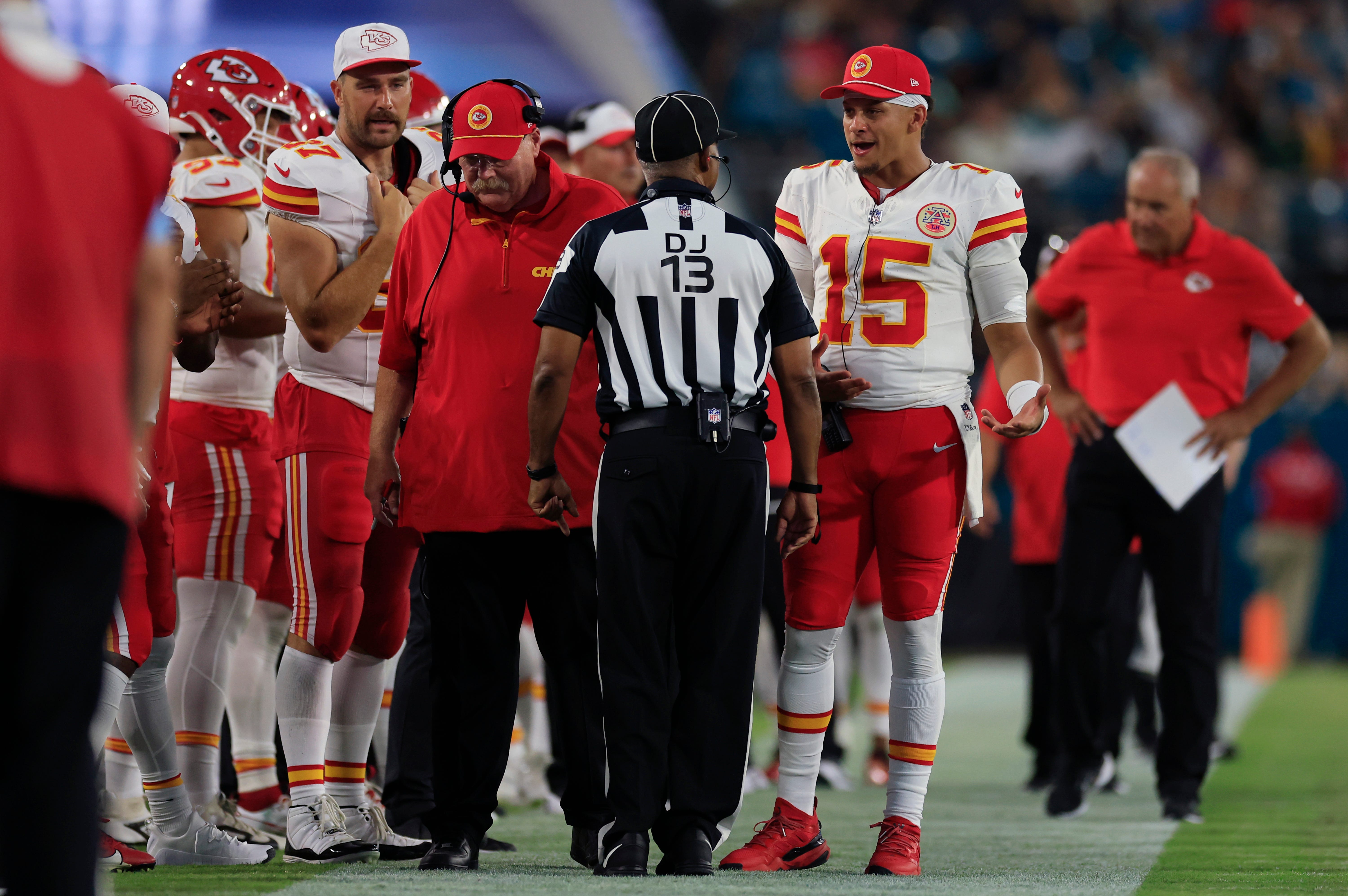 Kansas City Chiefs quarterback Patrick Mahomes (15) talks with down judge Patrick Turner (13) as head coach Andy Reid and tight end Travis Kelce (87) are on the sideline during the second quarter of a preseason NFL football game Saturday, Aug. 10, 2024 at EverBank Stadium in Jacksonville, Fla.