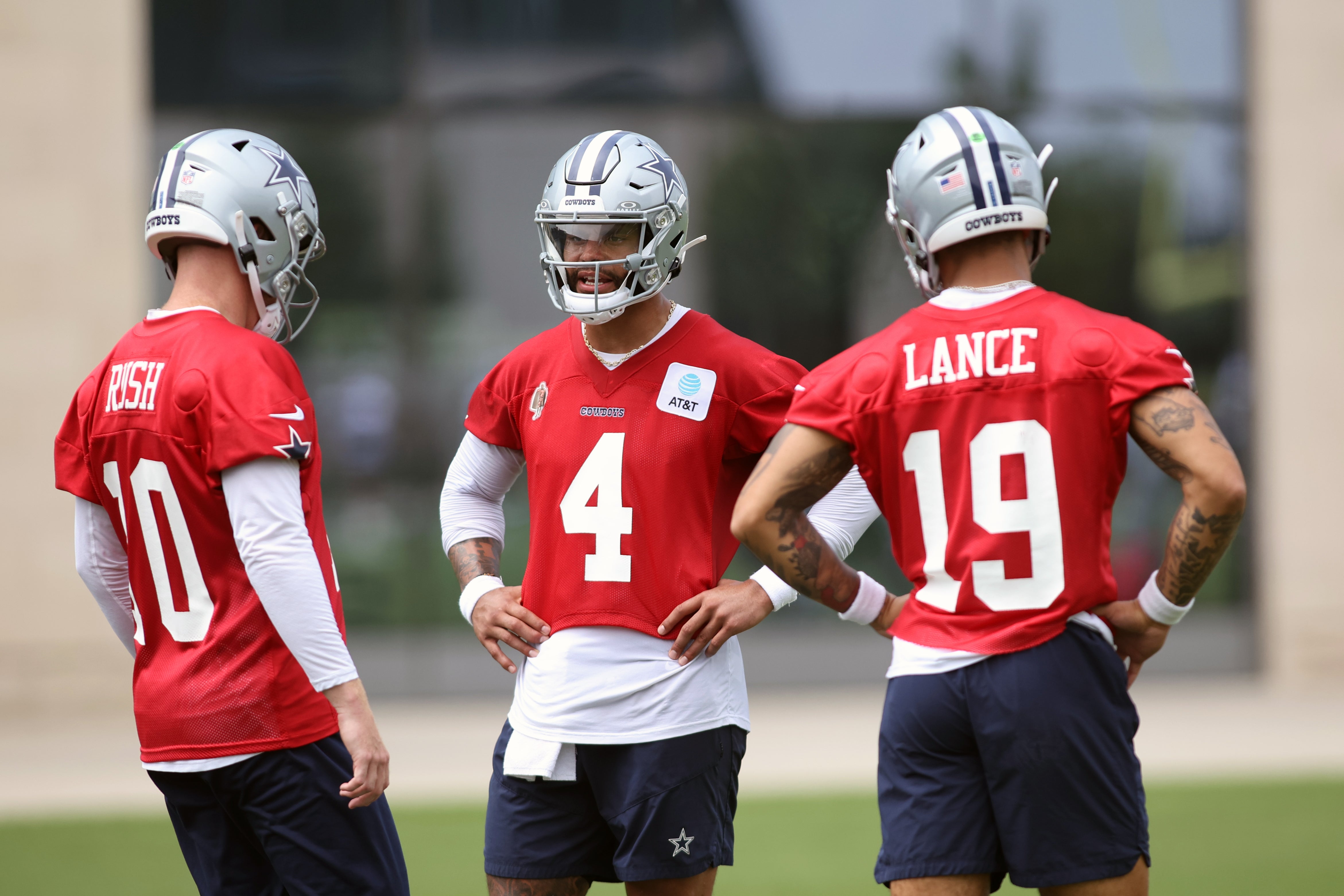 Dallas Cowboys quarterback Cooper Rush (10) and quarterback Dak Prescott (4) and quarterback Trey Lance (19) talk during practice at the Ford Center at the Star Training Facility in Frisco, Texas.