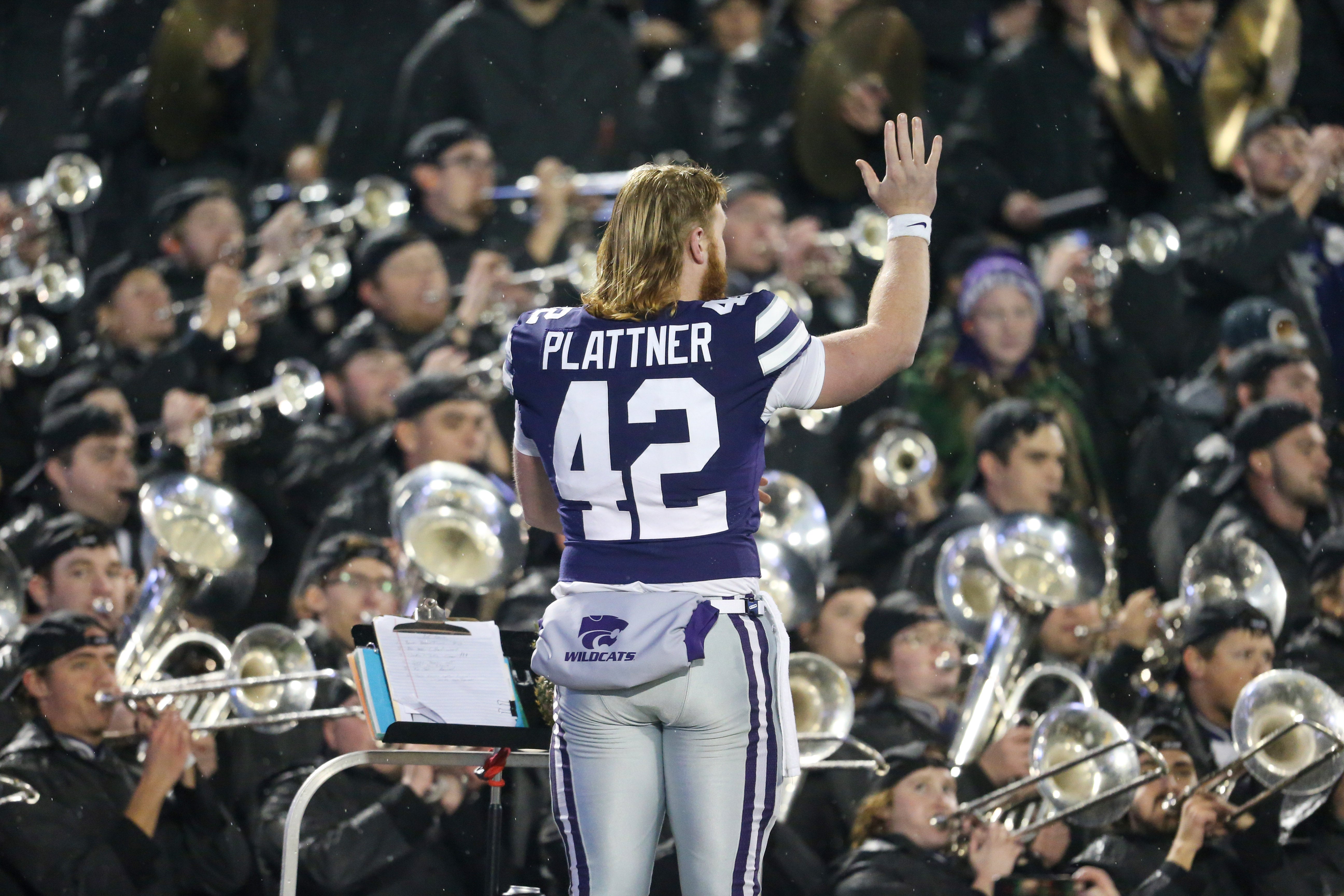 Nov 26, 2022; Manhattan, Kansas, USA; Kansas State Wildcats long snapper Randen Plattner (42) directs the marching band as they play the fight song after defeating the Kansas Jayhawks at Bill Snyder Family Football Stadium.