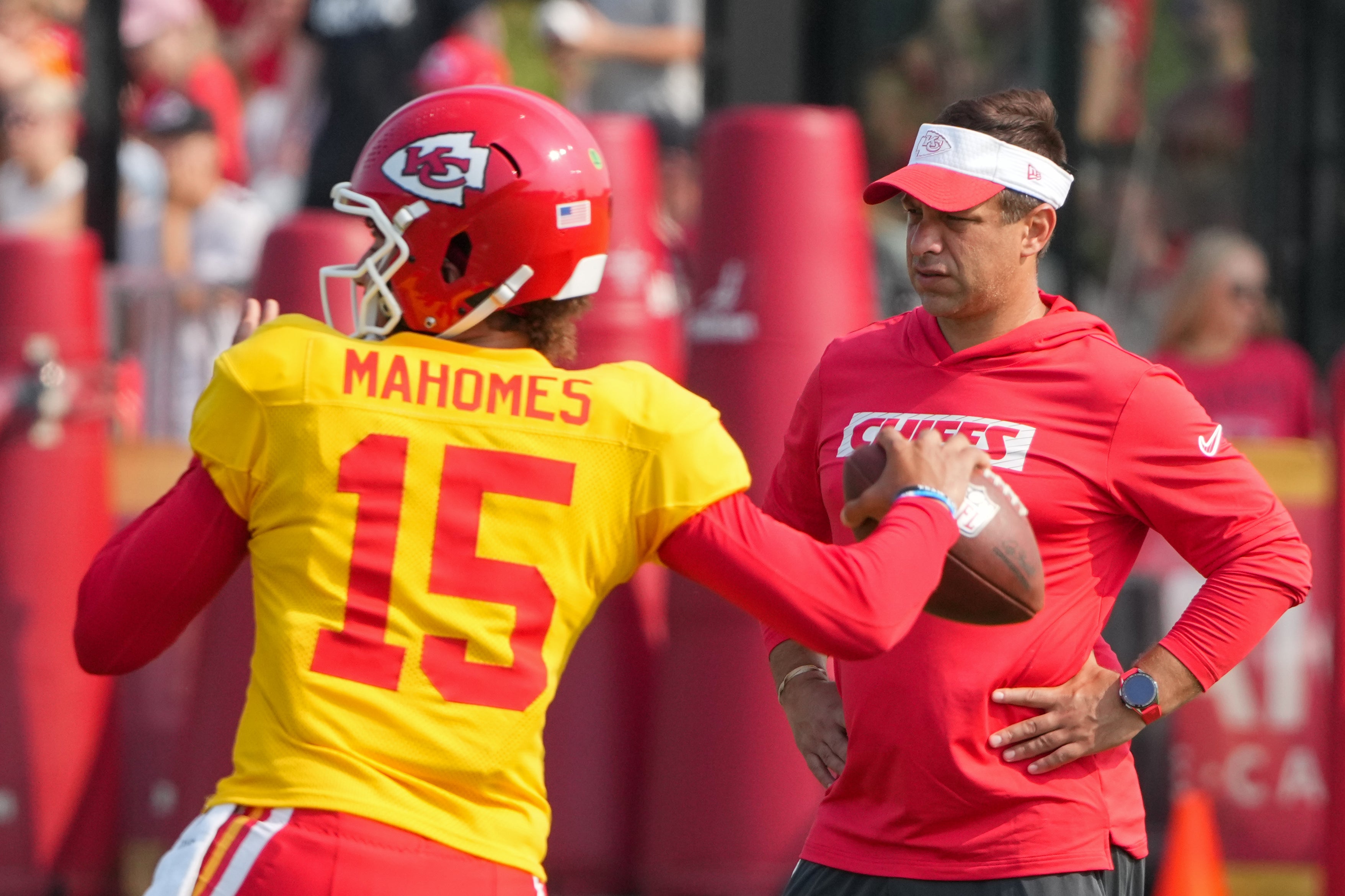 Jul 26, 2024; Kansas City, MO, USA; Kansas City Chiefs quarterback Patrick Mahomes (15) throws a pass as general manager Brett Veach watches in the background during training camp at Missouri Western State University.