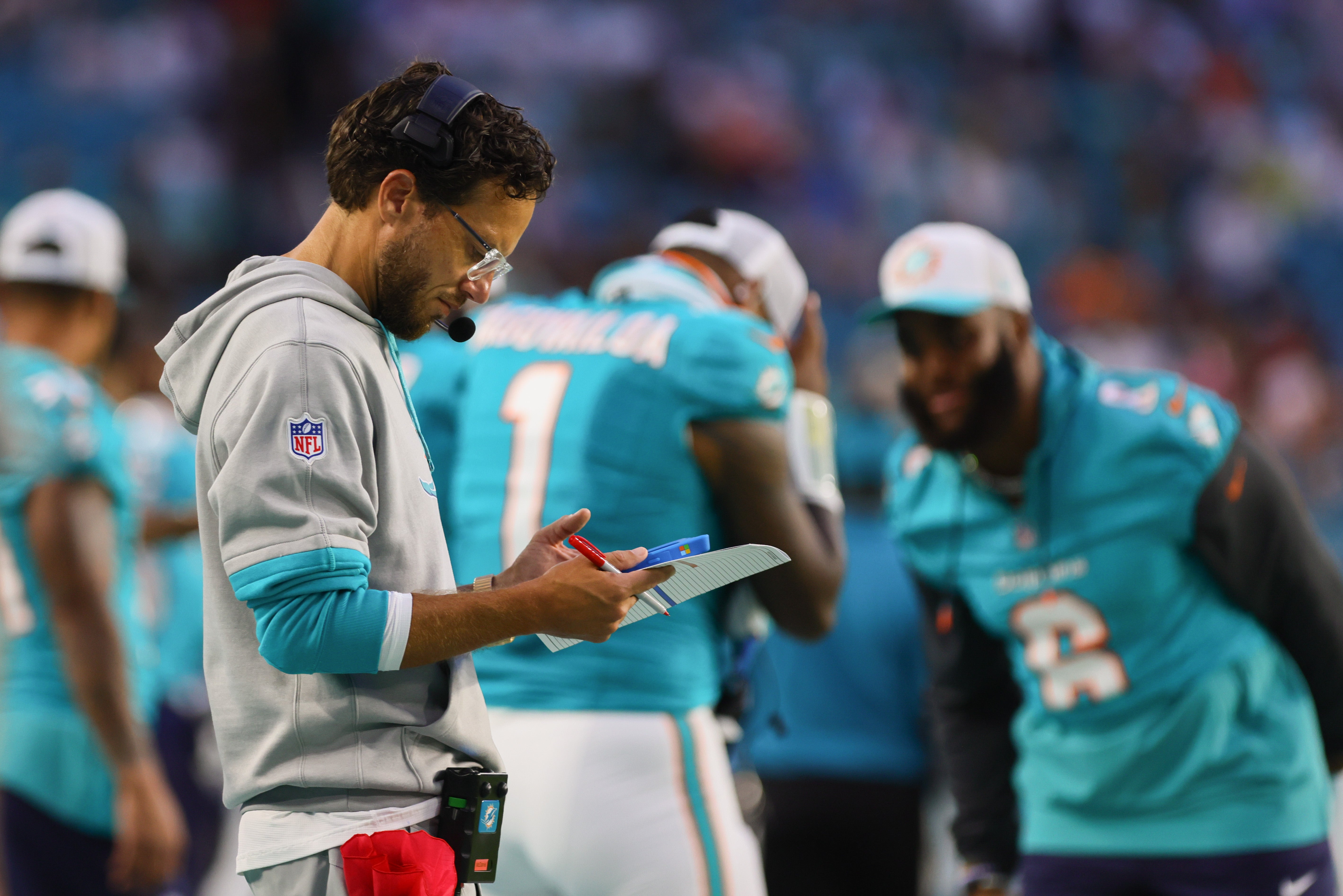 Aug 17, 2024; Miami Gardens, Florida, USA; Miami Dolphins head coach Mike McDaniel looks at a screen on the sideline against the Washington Commanders during the second quarter of a preseason game at Hard Rock Stadium.