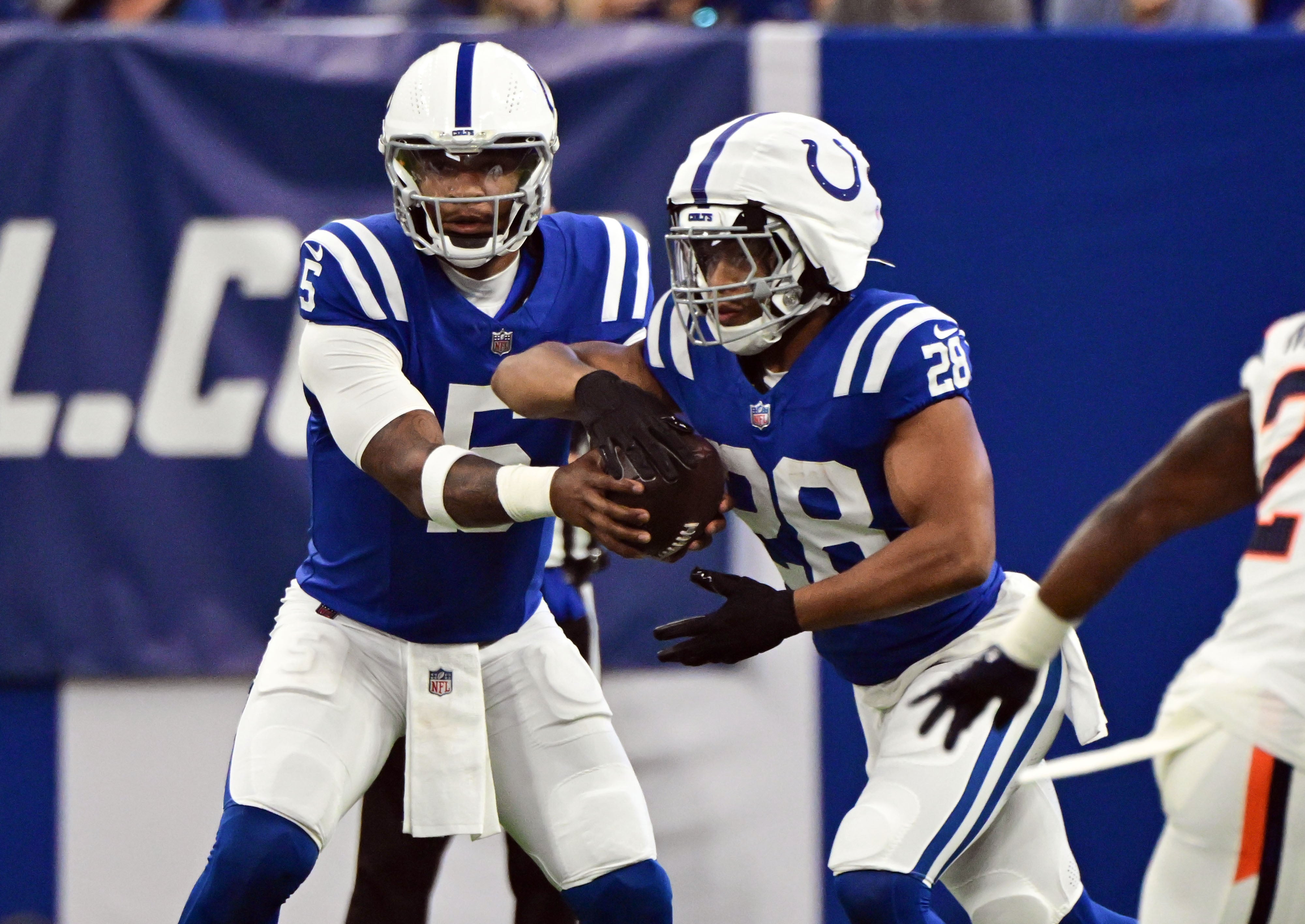 Aug 11, 2024; Indianapolis, Indiana, USA; Indianapolis Colts quarterback Anthony Richardson (5) hands the ball off to Indianapolis Colts running back Jonathan Taylor (28) during the first quarter against the Denver Broncos at Lucas Oil Stadium.