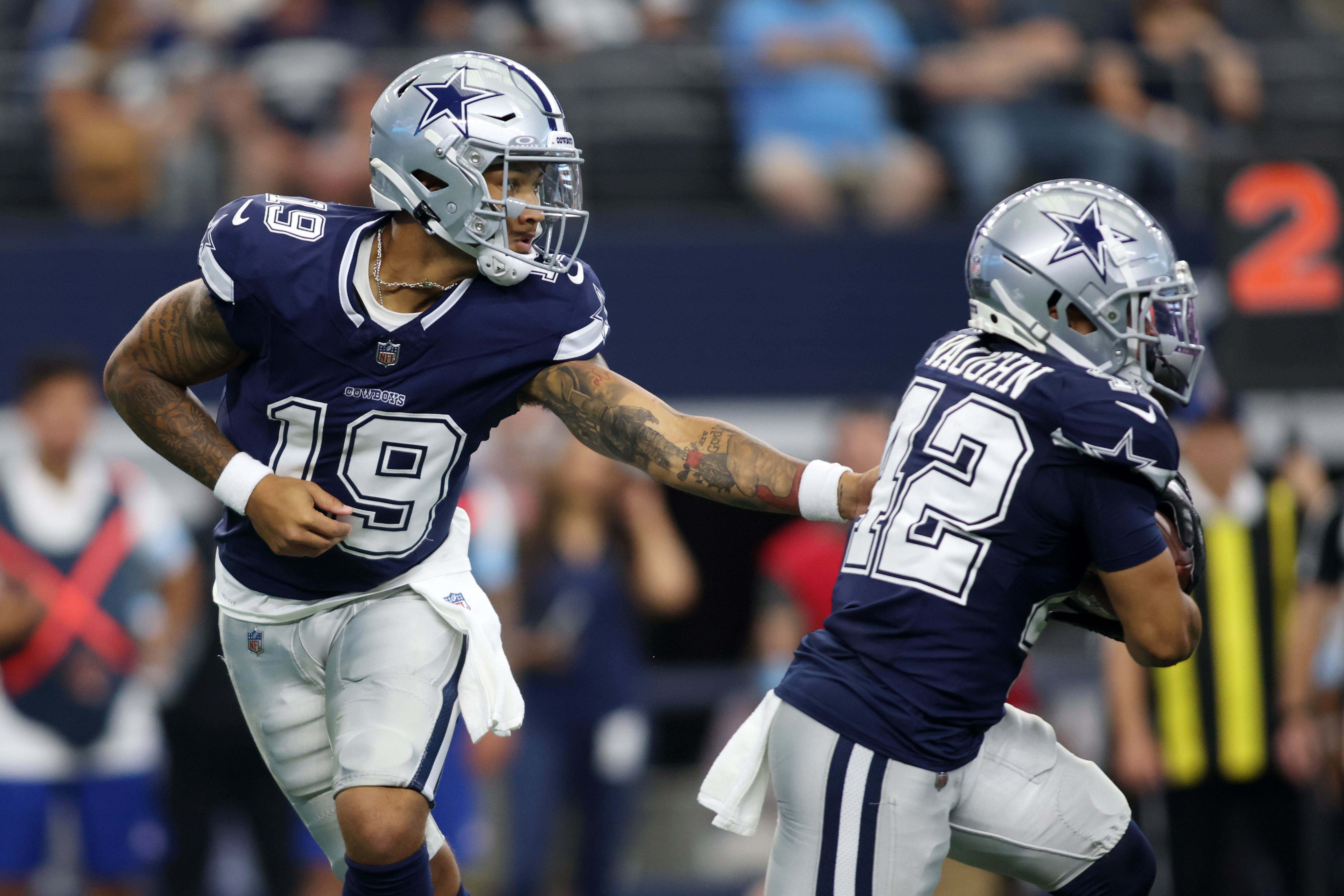 Dallas Cowboys quarterback Trey Lance (19) hands the ball off to running back Deuce Vaughn (42) in the first quarter against the Los Angeles Chargers at AT&T Stadium.