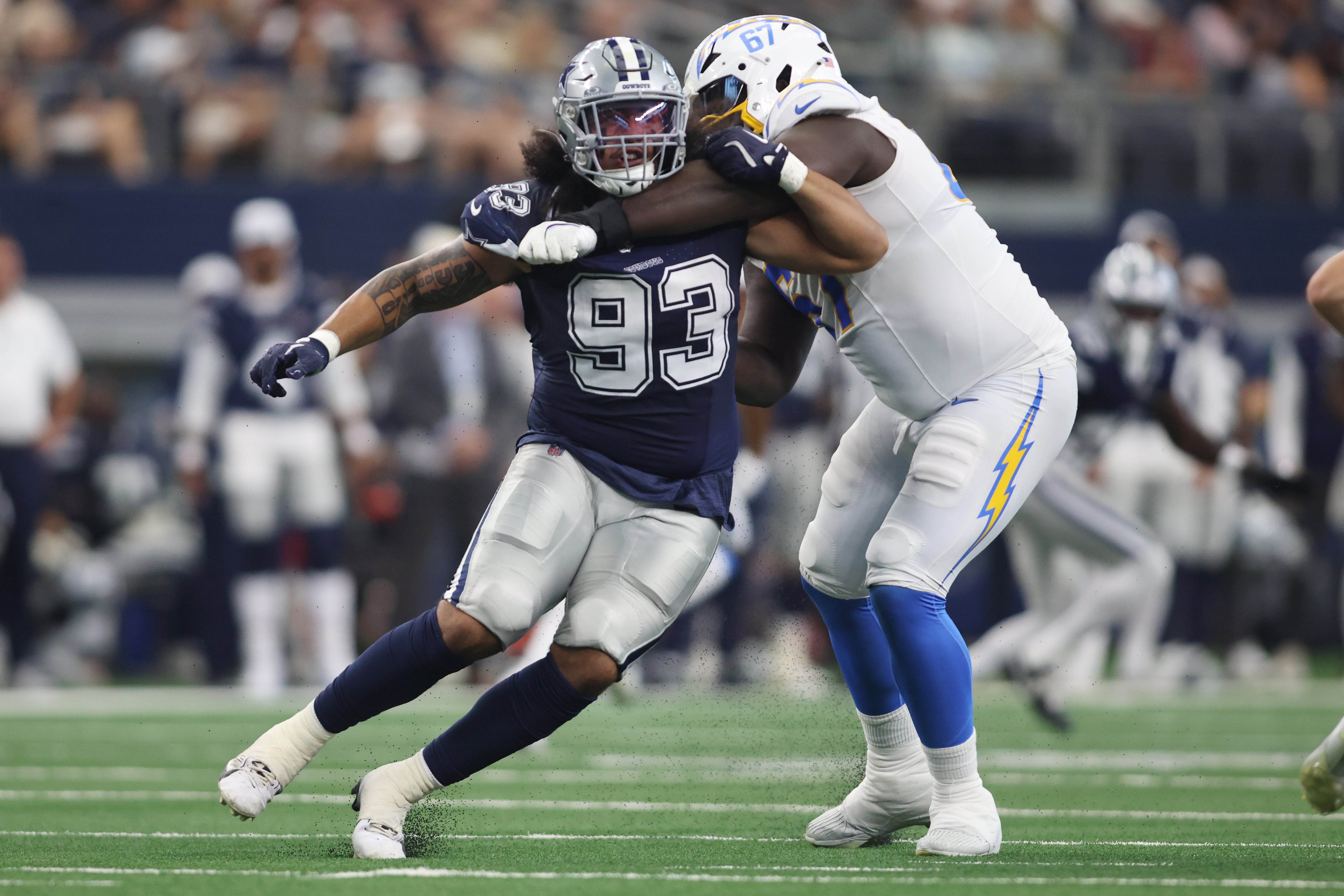 Dallas Cowboys defensive lineman Viliami Fehoko (93) is blocked by Los Angeles Chargers offensive tackle Alex Leatherwood (67) in the second quarter at AT&T Stadium.