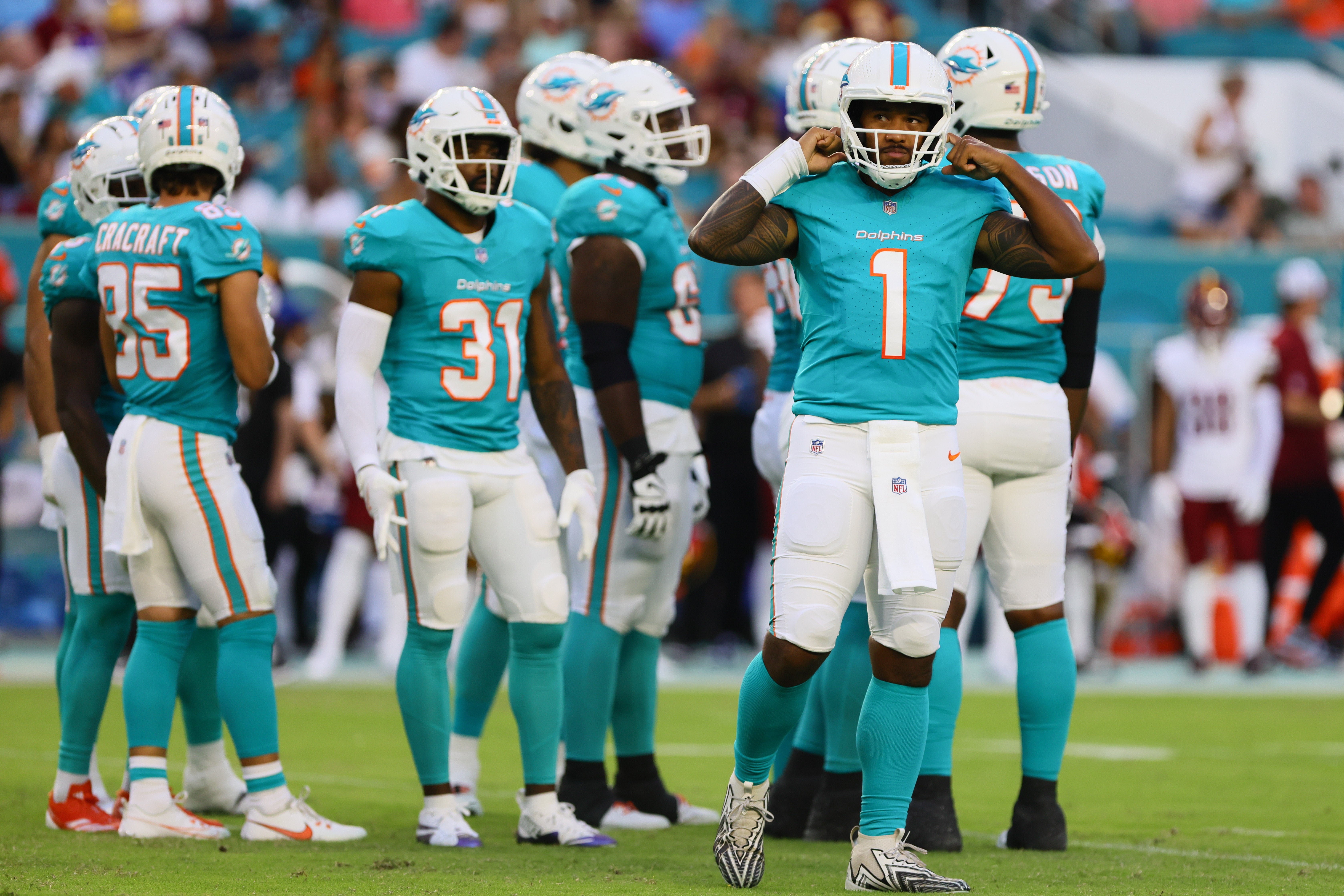 Aug 17, 2024; Miami Gardens, Florida, USA; Miami Dolphins quarterback Tua Tagovailoa (1) looks on from the field against the Washington Commanders during the first quarter of a preseason game at Hard Rock Stadium.