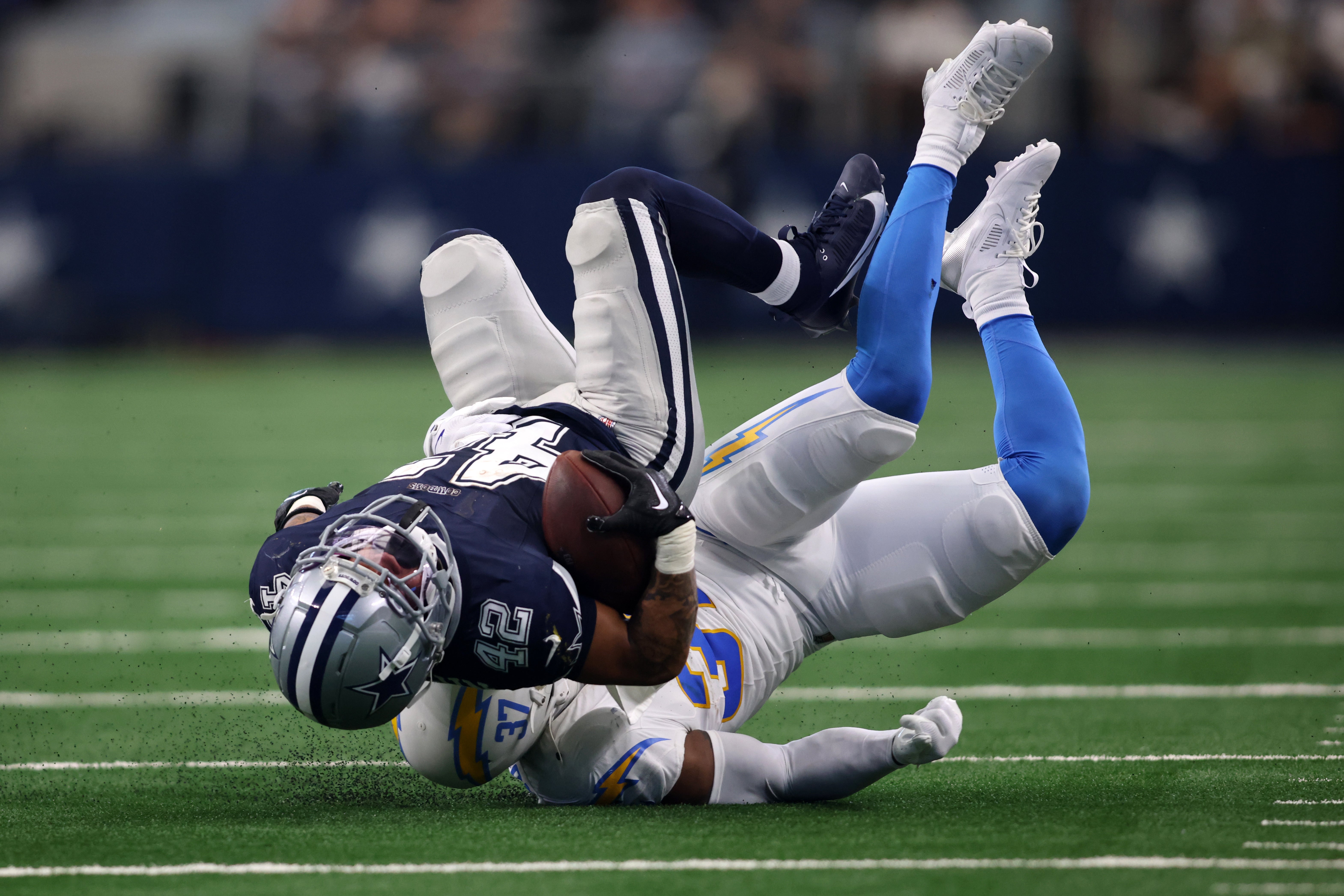 Los Angeles Chargers safety Thomas Harper (37) tackles Dallas Cowboys running back Deuce Vaughn (42) in the first half at AT&T Stadium.