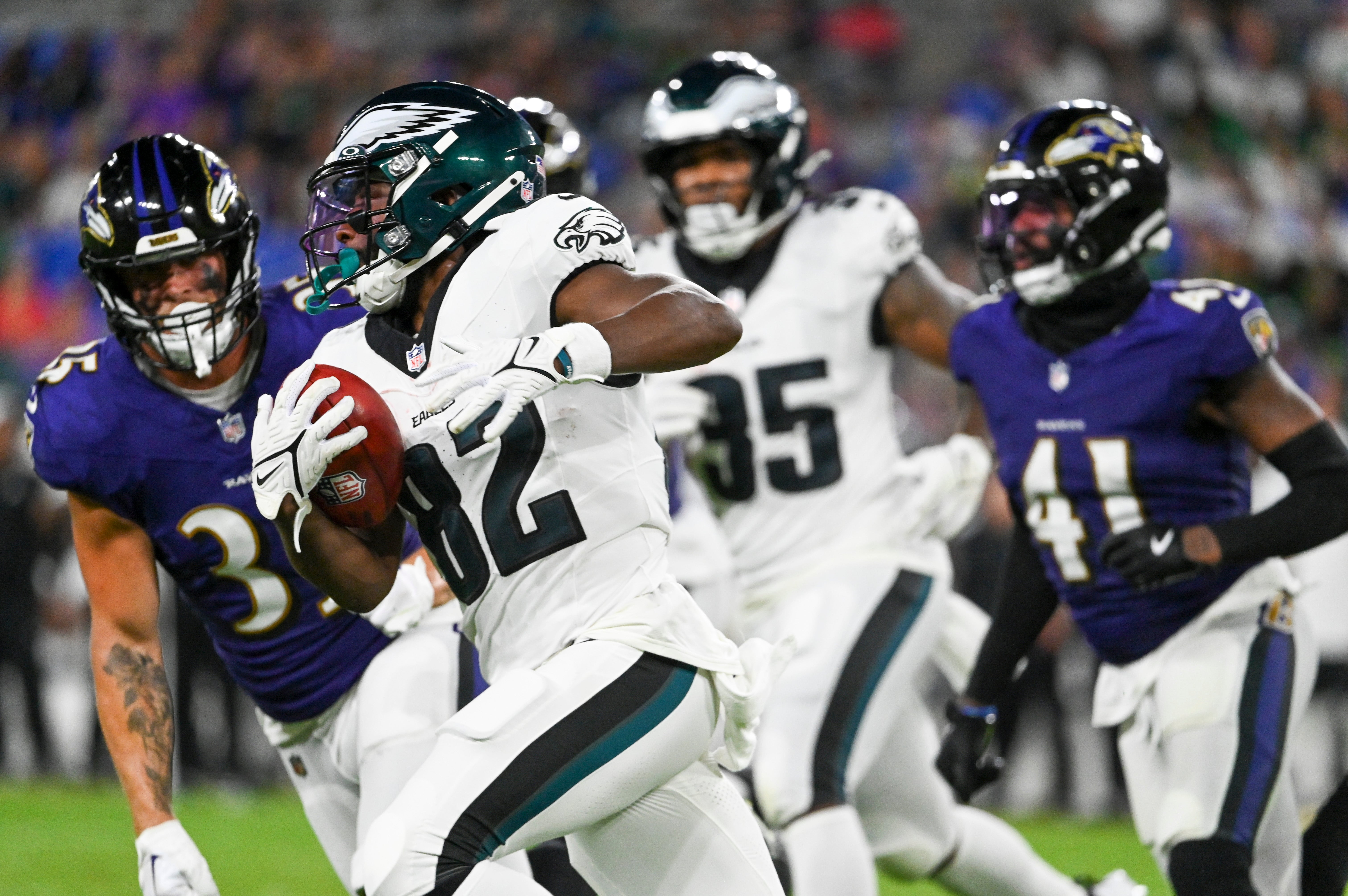 Philadelphia Eagles wide receiver Ainias Smith (82) returns a punt as Baltimore Ravens tight end Mike Rigerman (35) defends during the second half of a preseason game at M&T Bank Stadium.
