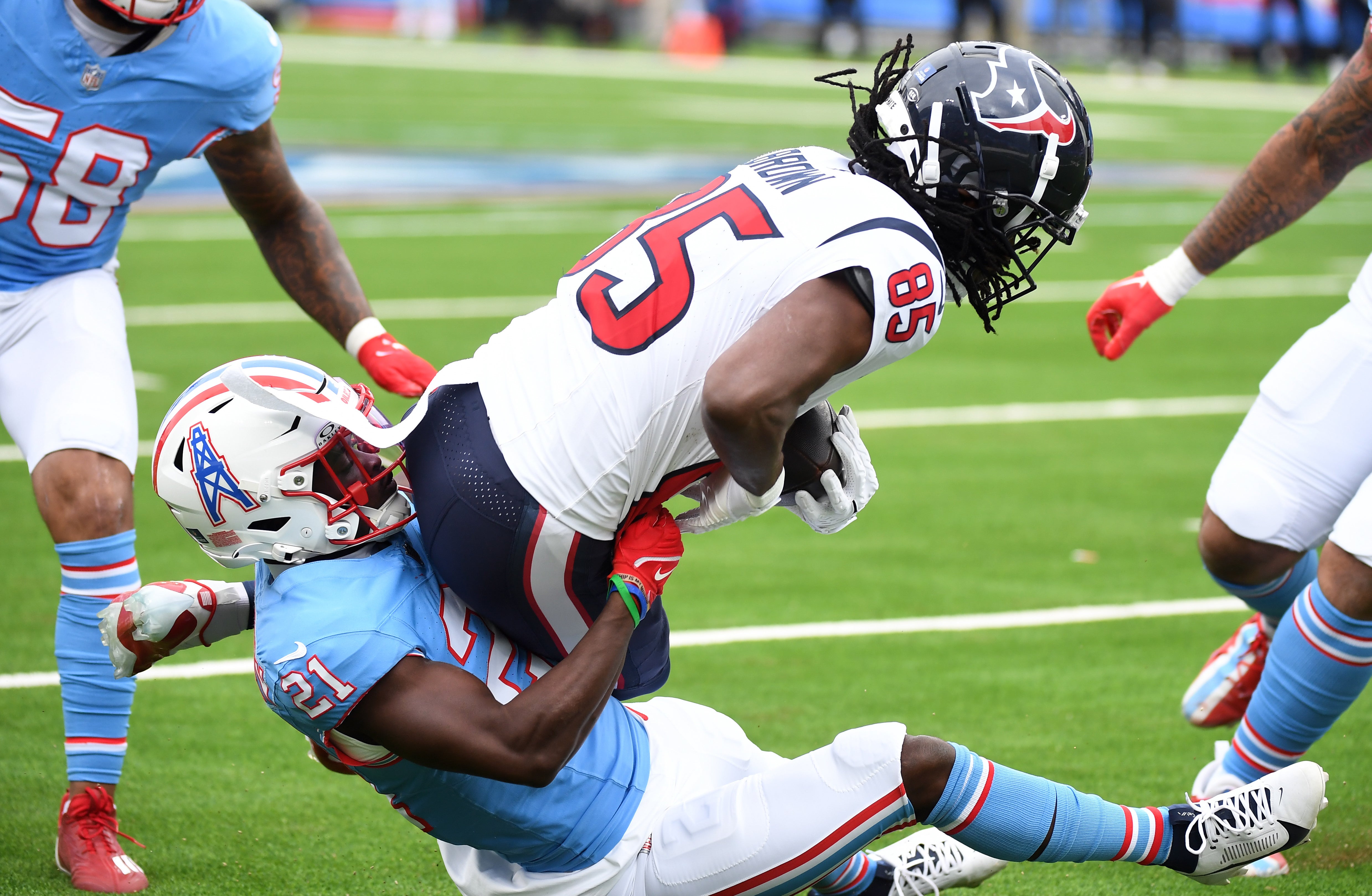 Dec 17, 2023; Nashville, Tennessee, USA; Houston Texans wide receiver Noah Brown (85) is tackled by Tennessee Titans cornerback Roger McCreary (21) after a reception during the first half at Nissan Stadium.